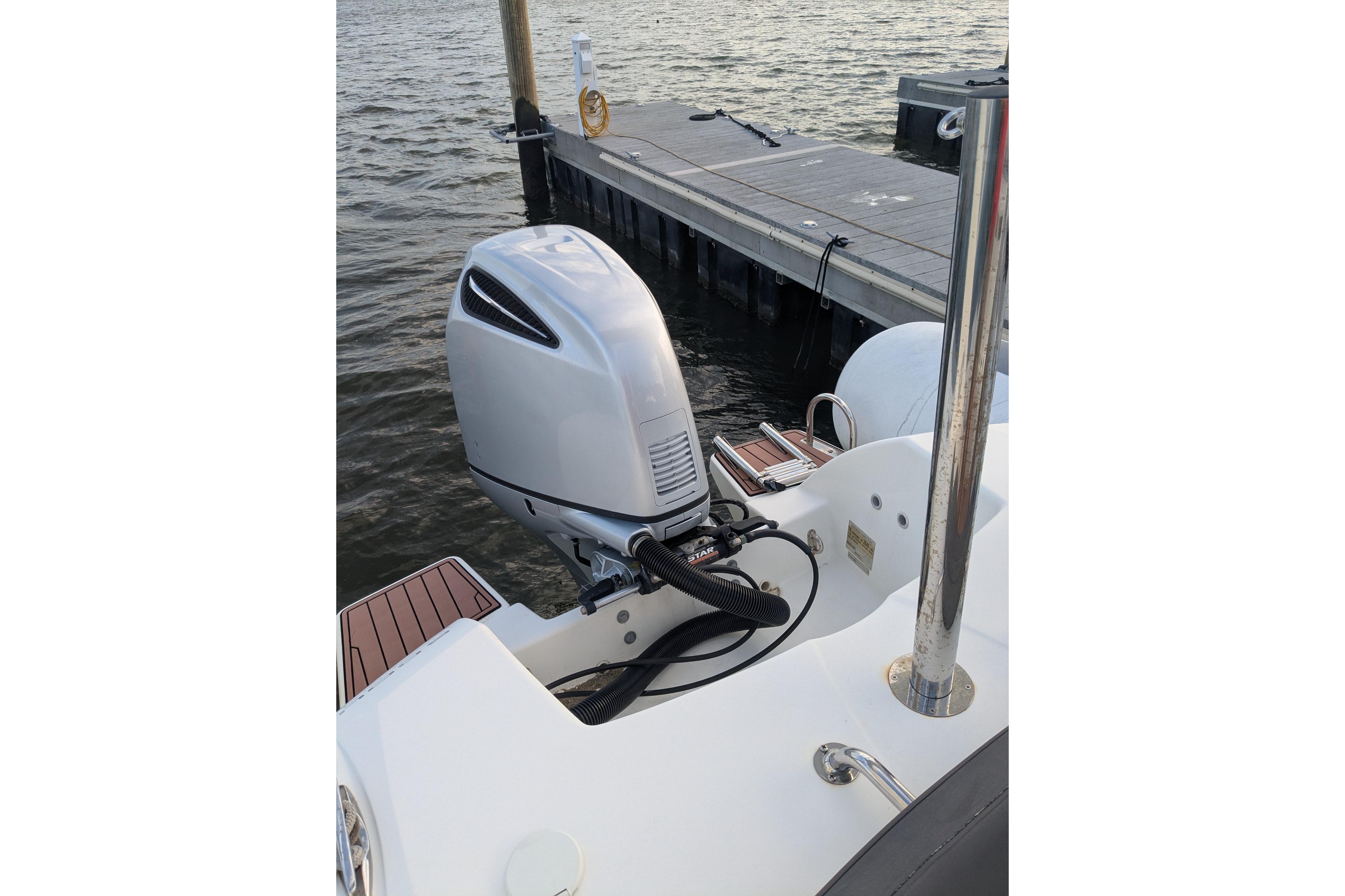 2016 Brig E780 boat with outboard motor docked by the water.