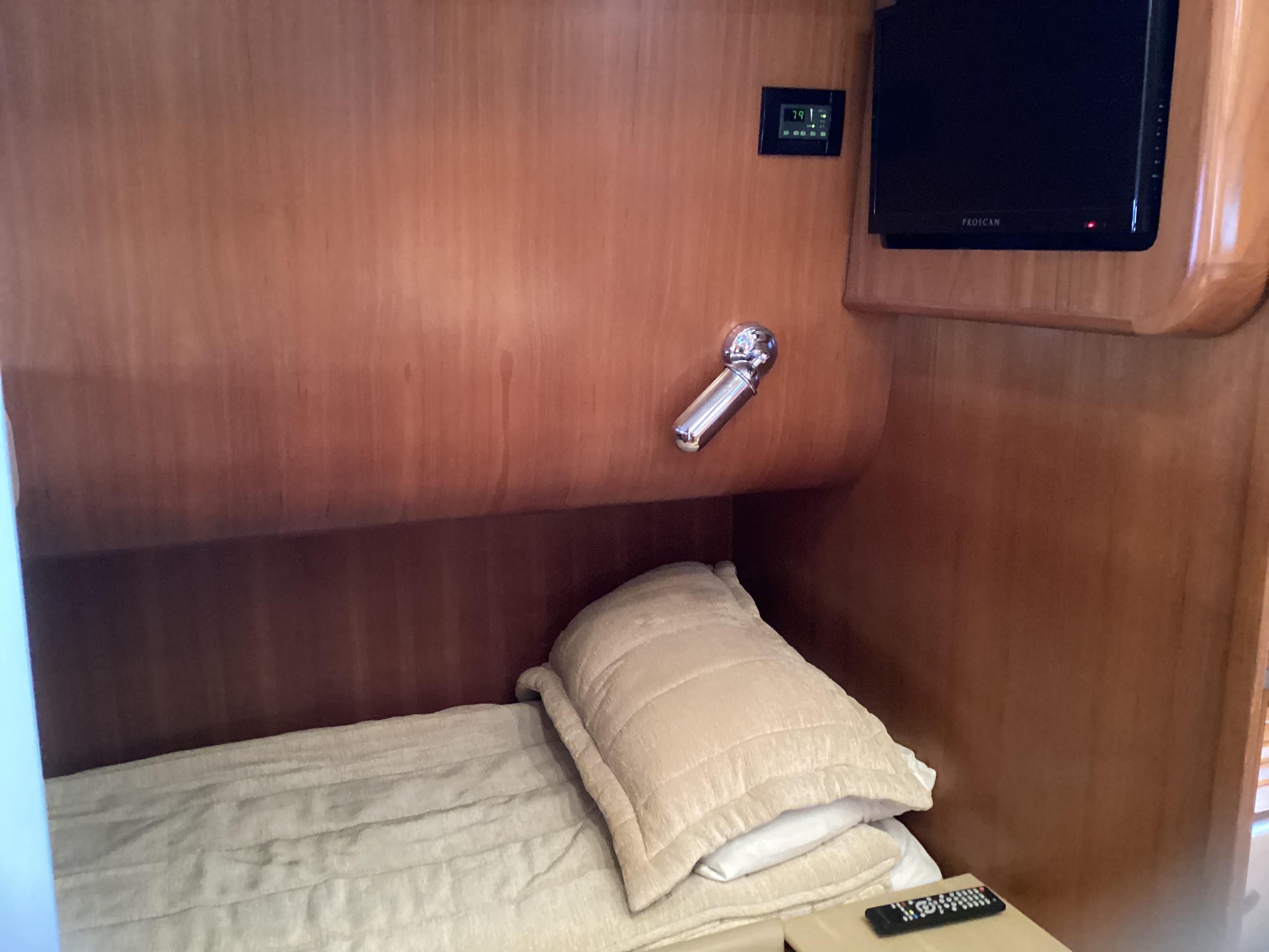 Cozy cabin interior of 2004 Tiara Yachts 4400 Sovran with bed and TV.