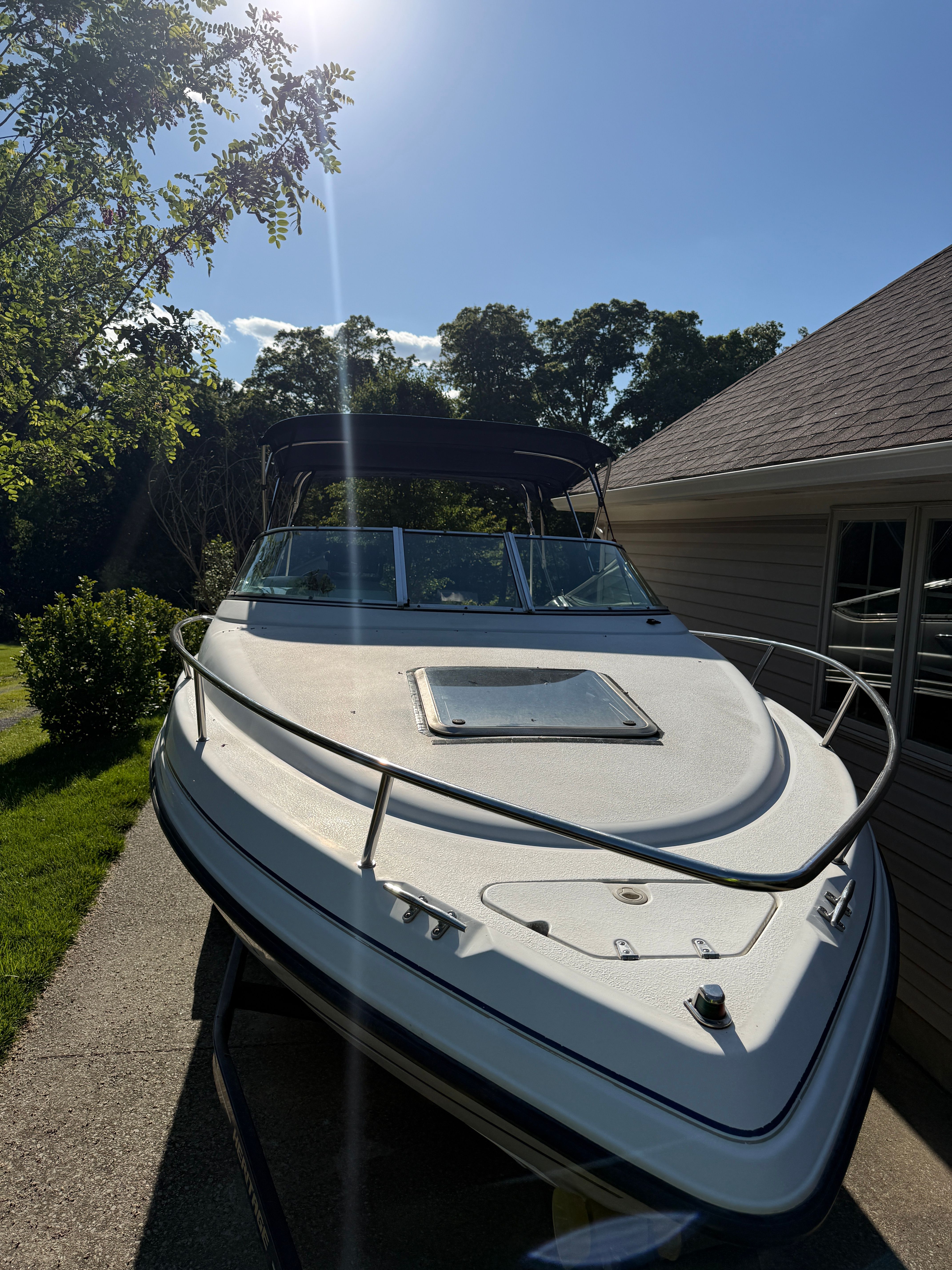 1999 Custom 2335 Cuddy Cabin boat on trailer outdoors.