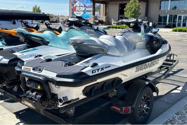 A Sea-Doo GTX jet ski is on a trailer in an outdoor area.