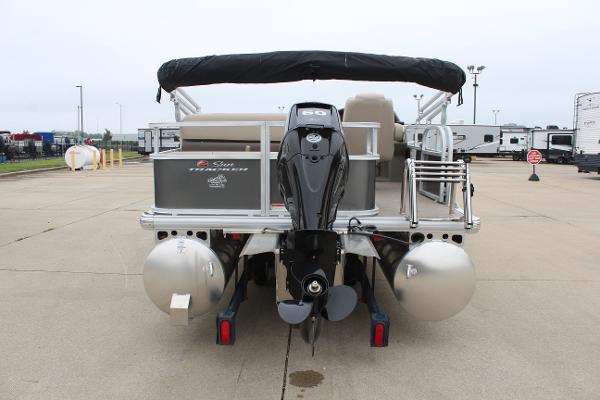 2025 Sun Tracker Party Barge 18 DLX pontoon boat, rear view with motor, parked outdoors.
