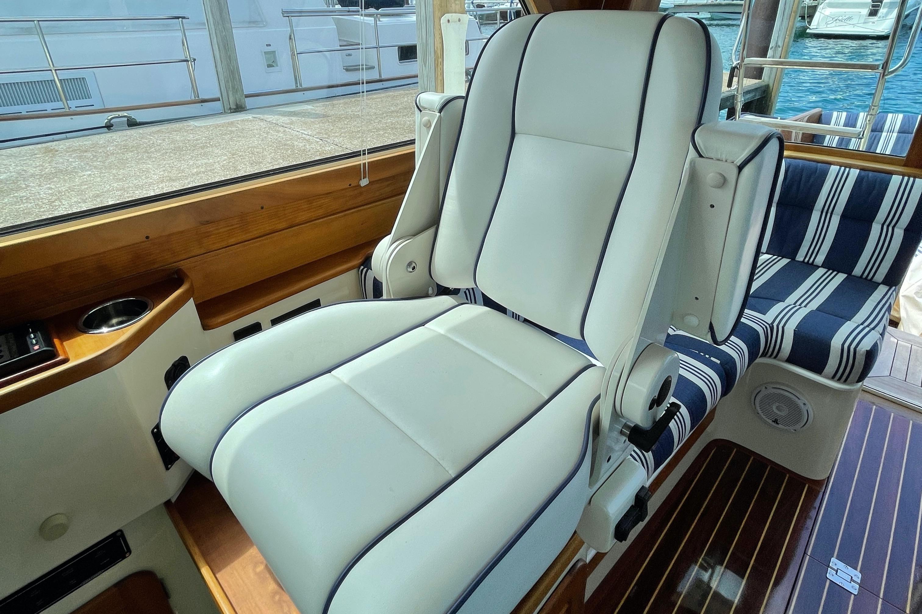 Luxurious seating on 2007 Hinckley Talaria 44 Flybridge yacht with striped cushions and wooden accents.
