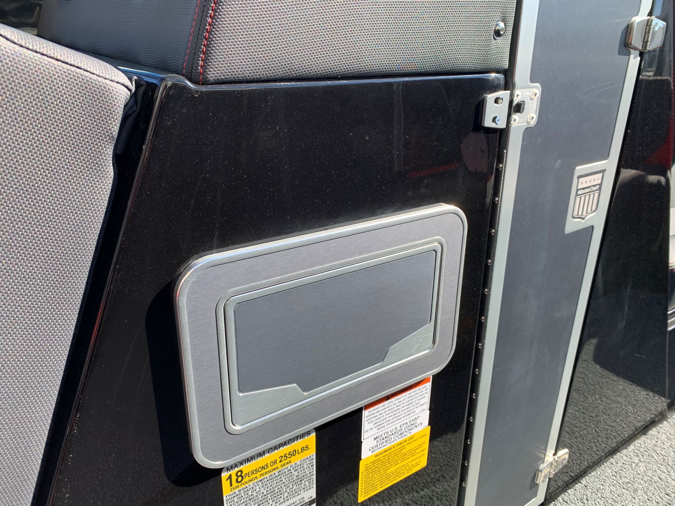 Close-up of a section of a 2020 MasterCraft X24 boat with black paneling.