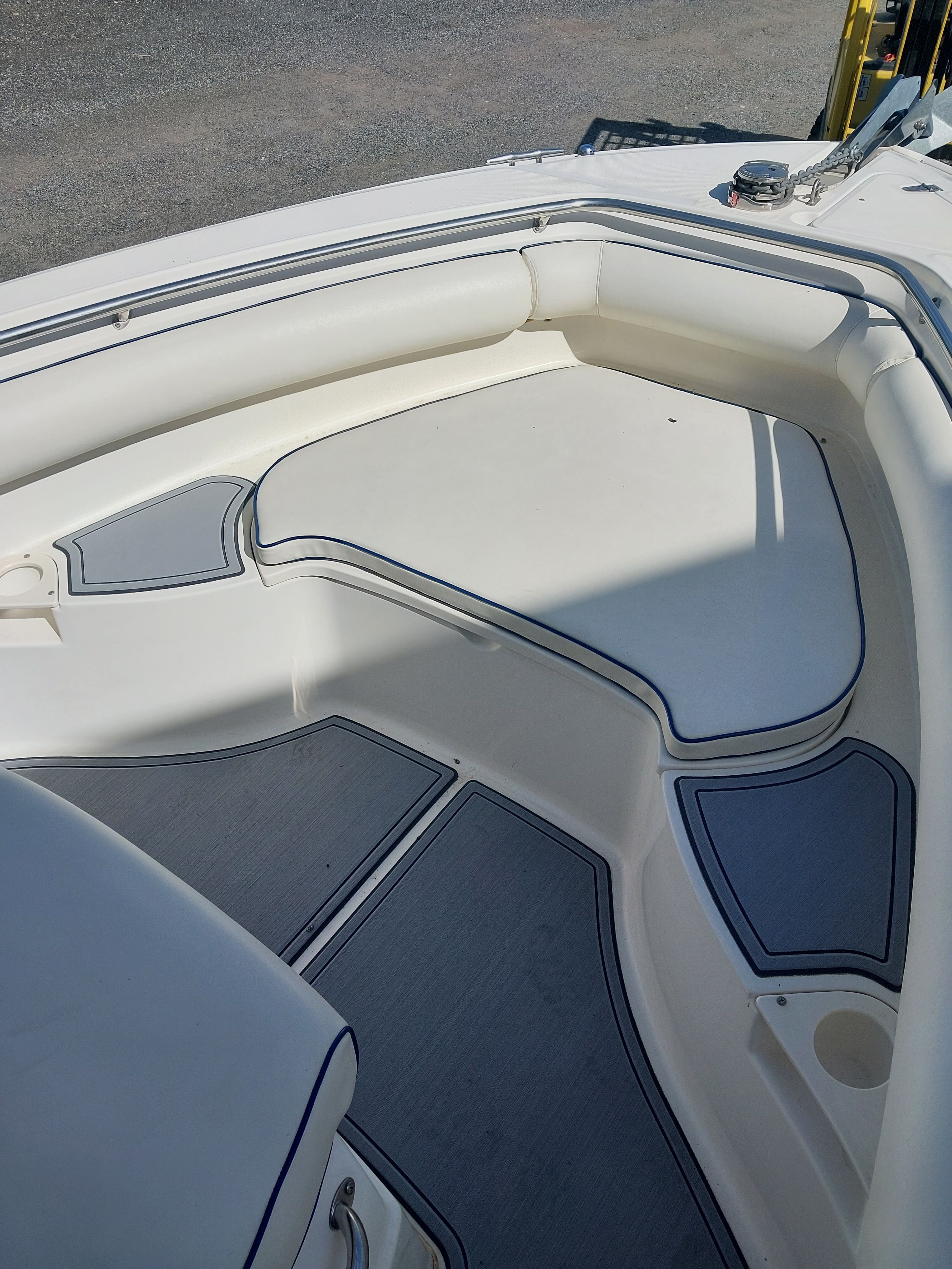 The image shows the bow area of a 2005 Boston Whaler 240 Outrage with white cushions.