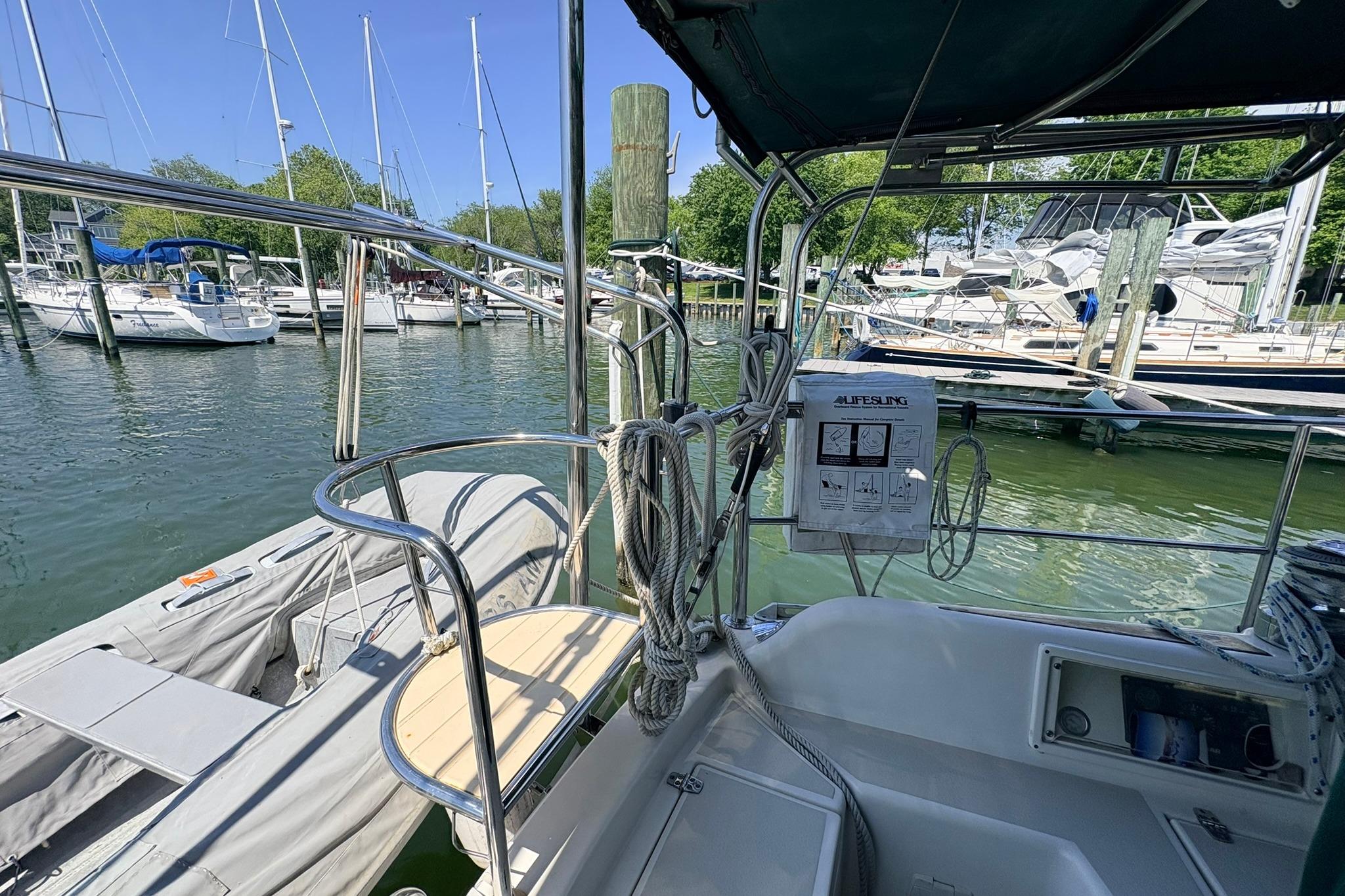 Sailboat docked at marina, featuring Caliber 40LRC SE, 2009 model, with lifebuoy equipment.