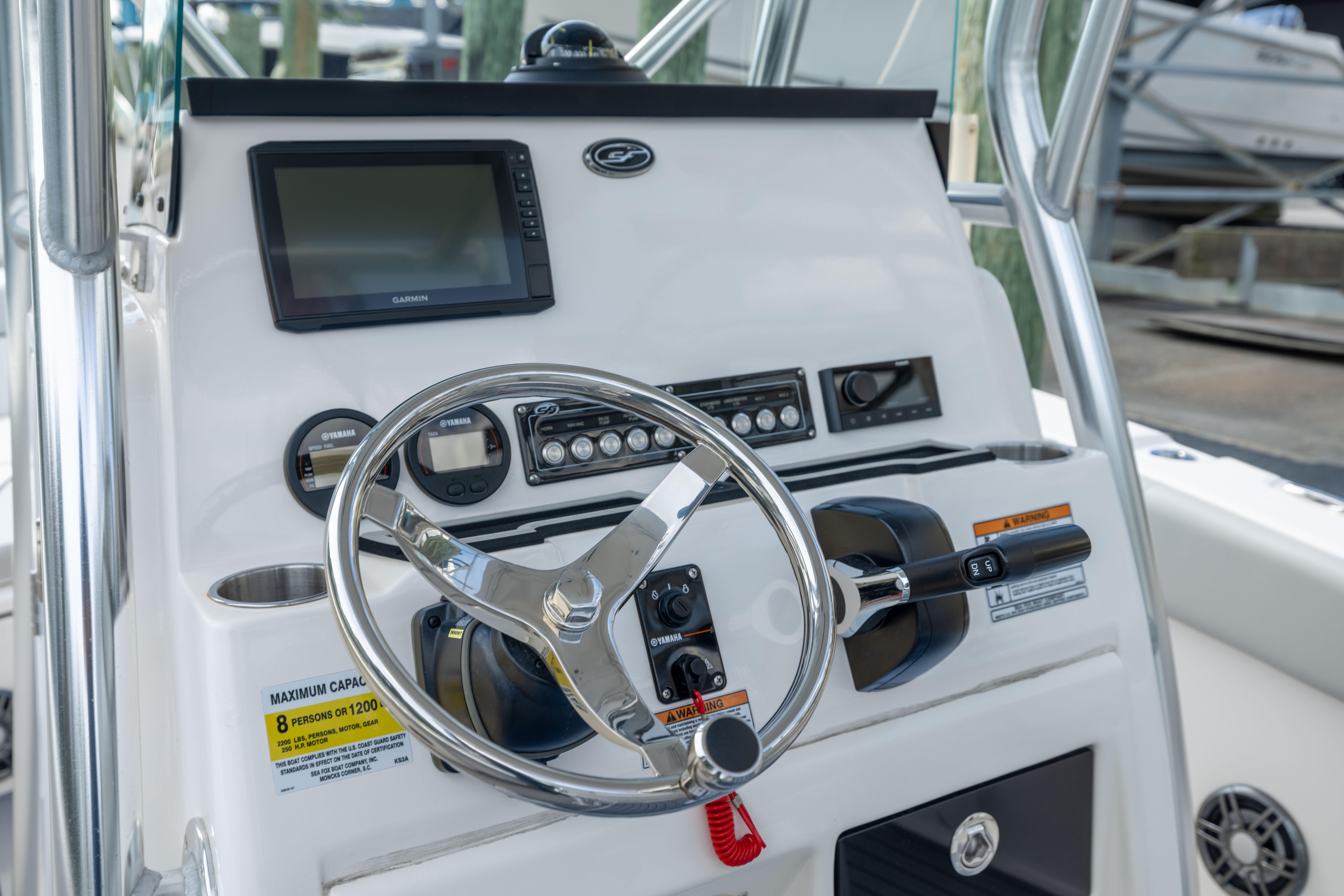 2023 Sea Fox 228 Commander boat dashboard with steering wheel and navigation controls.