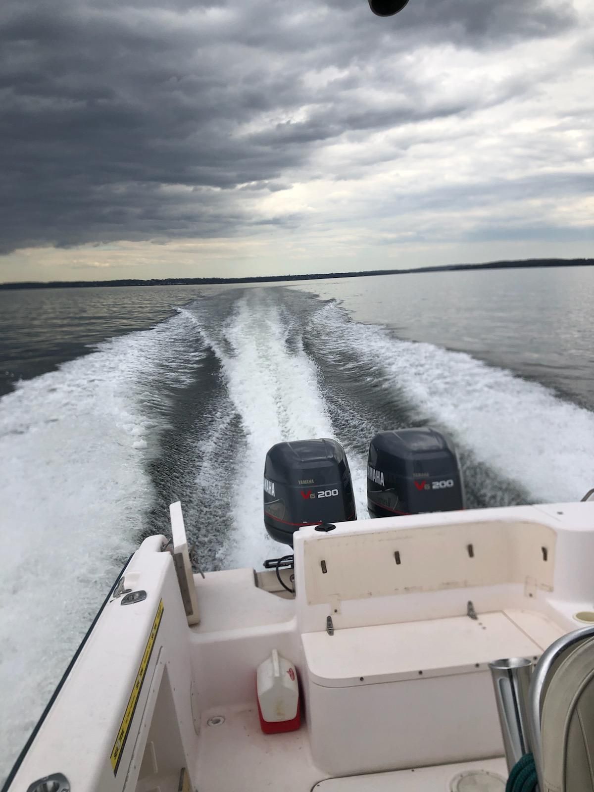A 1997 Grady-White Chase 263 boat speeding across the water, featuring two outboard engines.