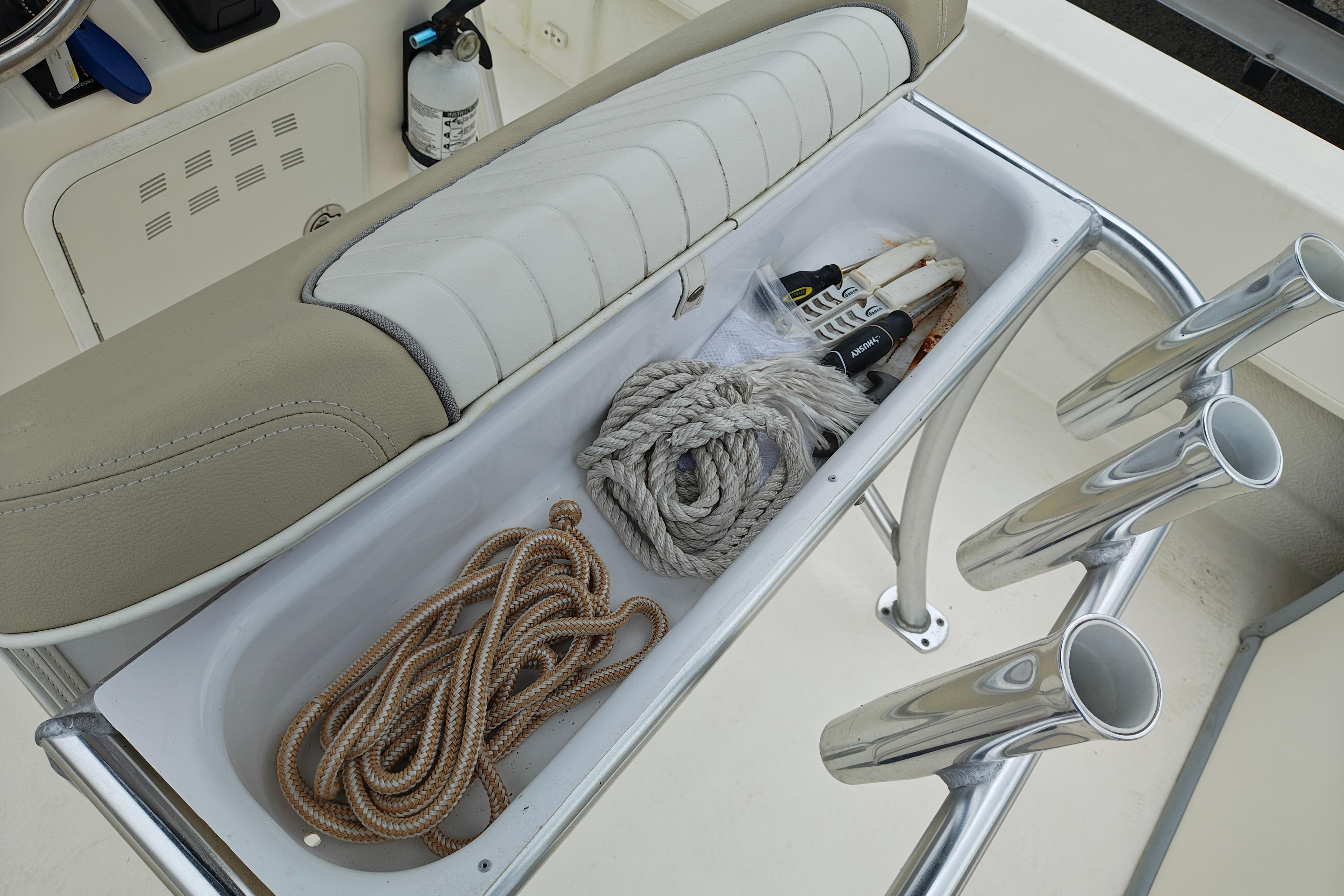 Storage compartment on a 2018 Sundance B20CCR boat with ropes and tools.