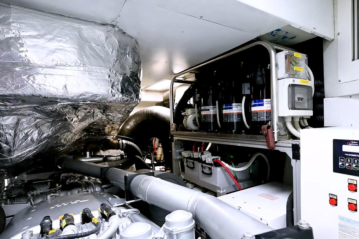 Engine room of a 2015 Pershing 92 yacht, showcasing complex machinery and equipment.