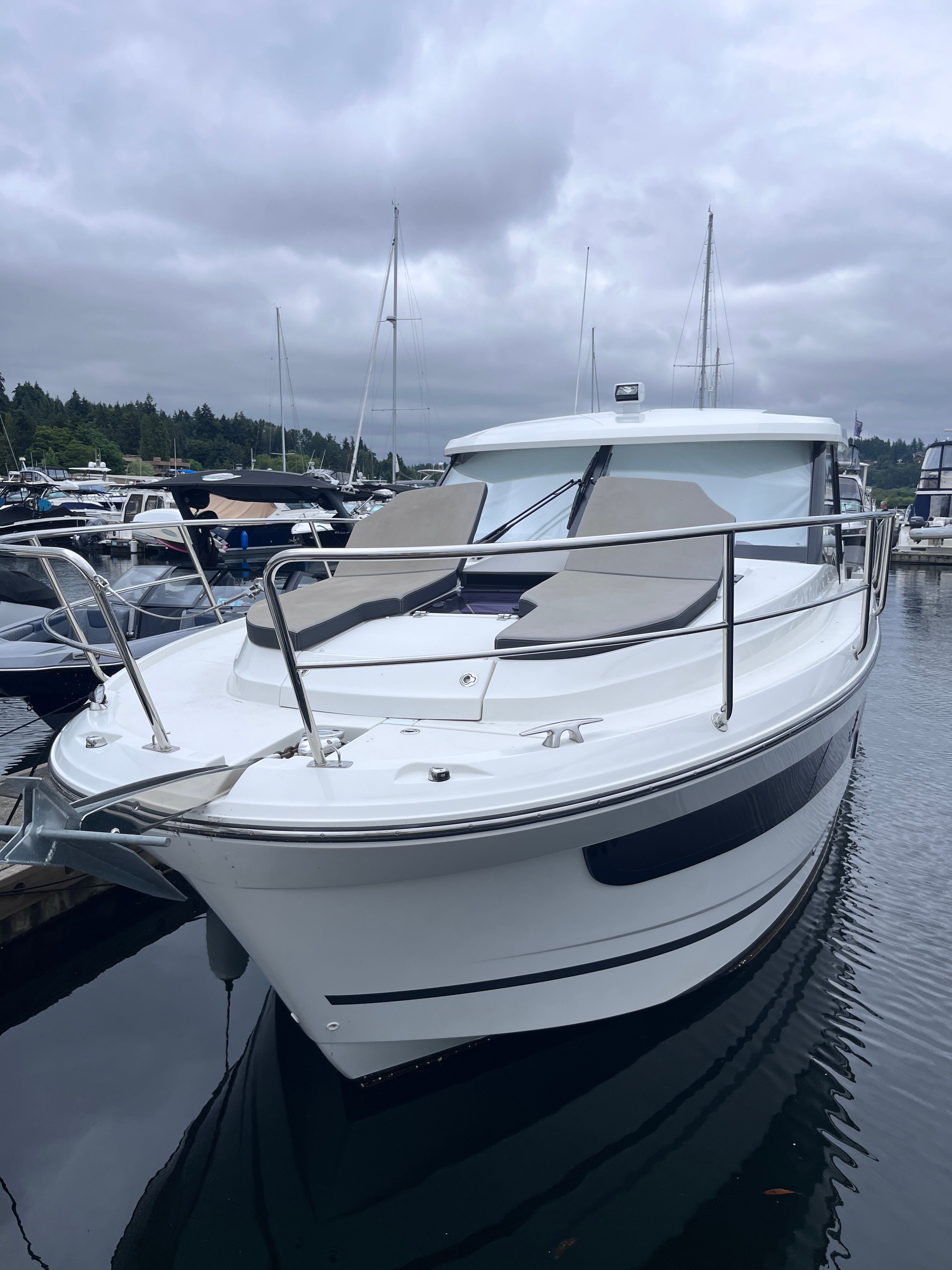 A 2021 Jeanneau NC 1095 docked in a marina. It features a modern design and spacious foredeck area.