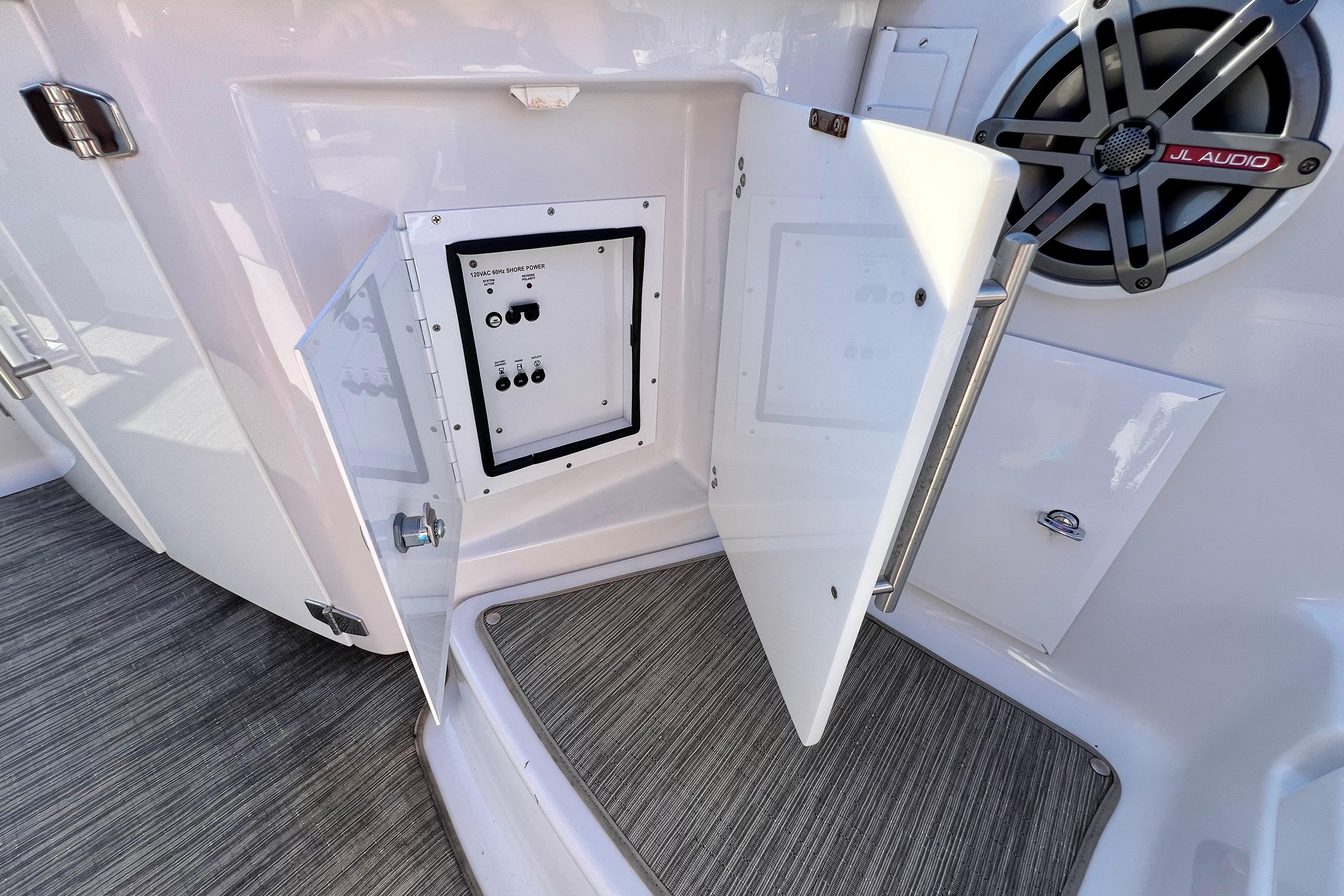 2019 Four Winns Horizon H290 boat interior with open control panel and JL Audio speaker.
