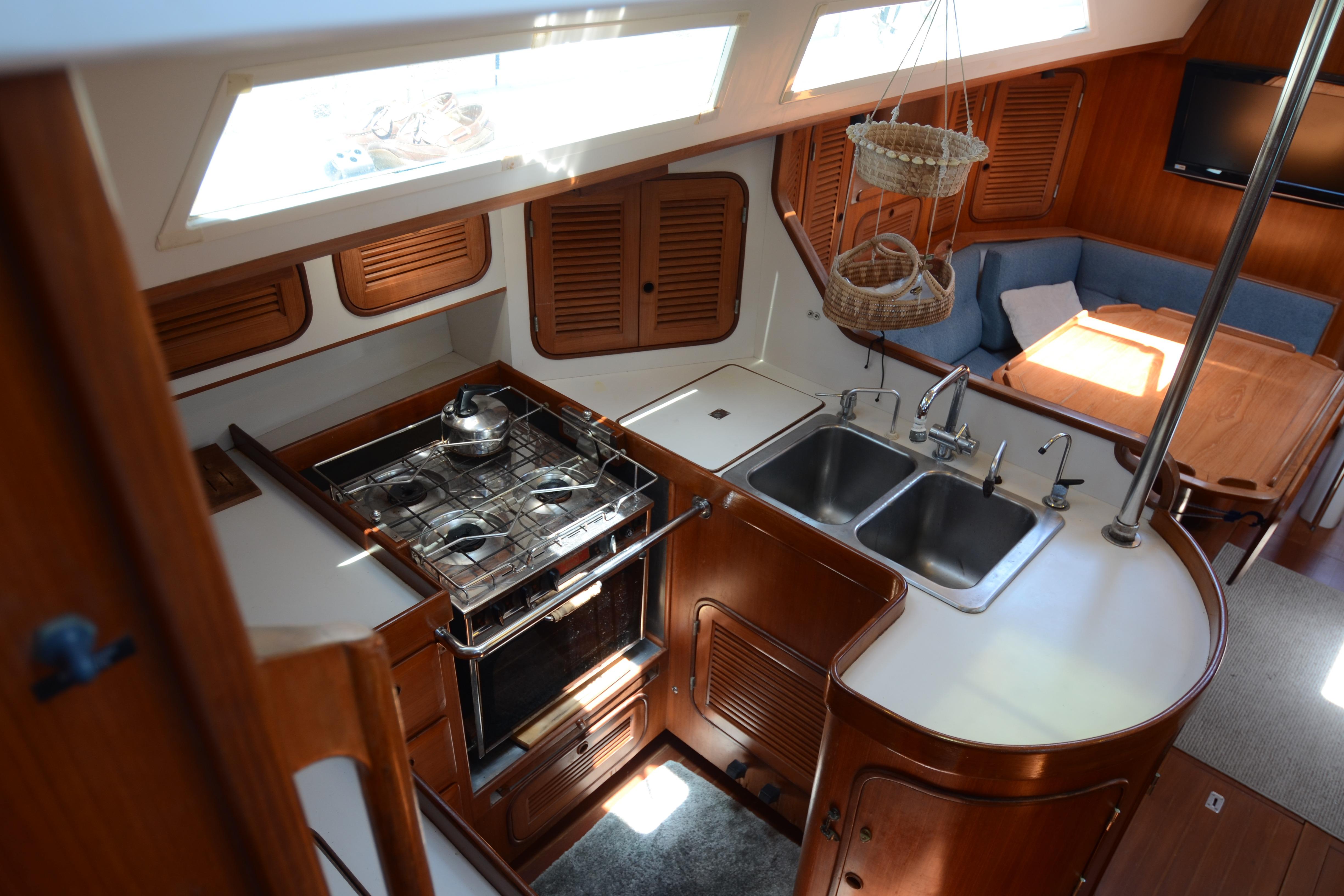Interior of 1987 Norseman 400 yacht featuring kitchen and dining area with wooden cabinetry.