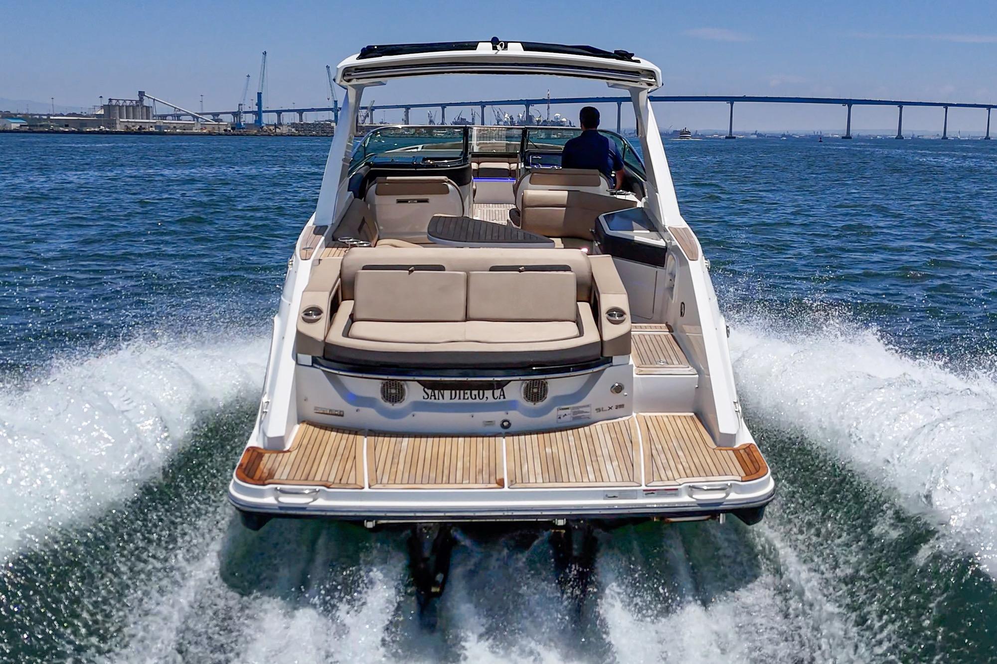 2018 Sea Ray SLX 310 cruising on open water near a bridge.
