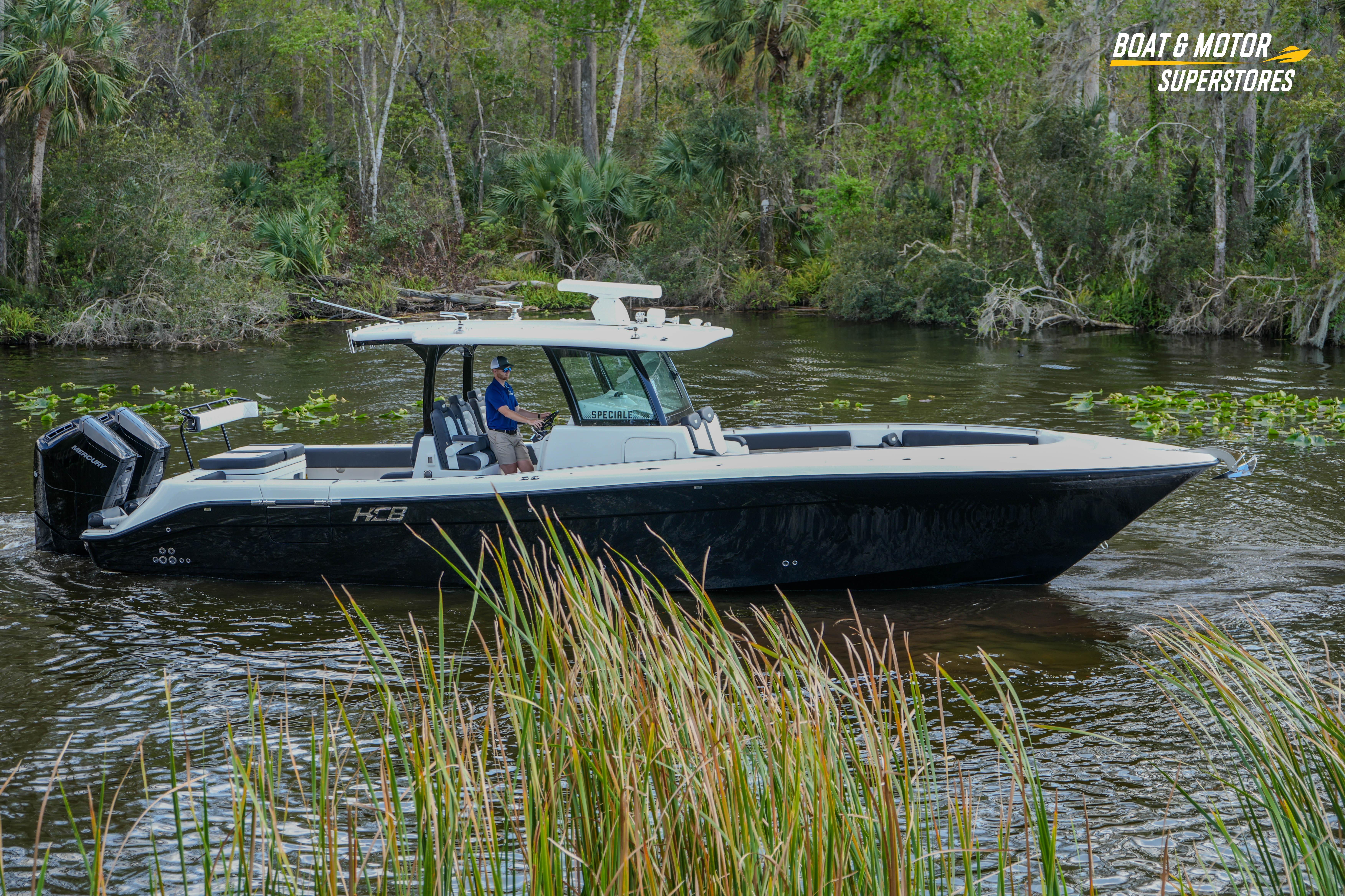 2023 HCB 39 Speciale boat cruising on a scenic river with lush greenery.
