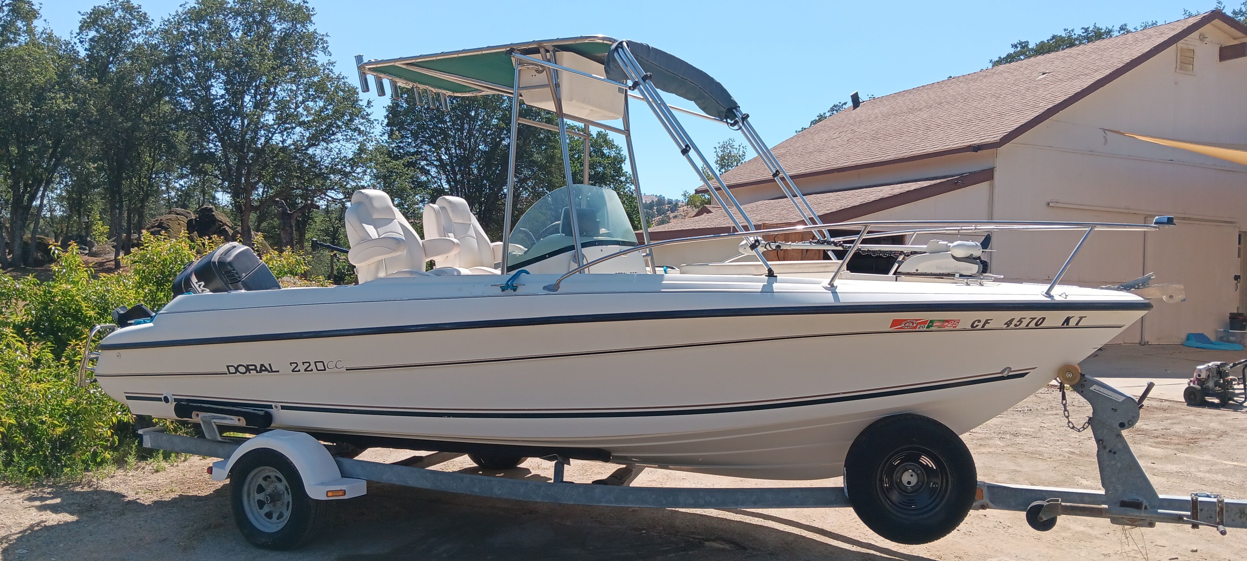 A 1998 Doral Ibiza 22 CC boat on a trailer, featuring a sunshade and two seats.