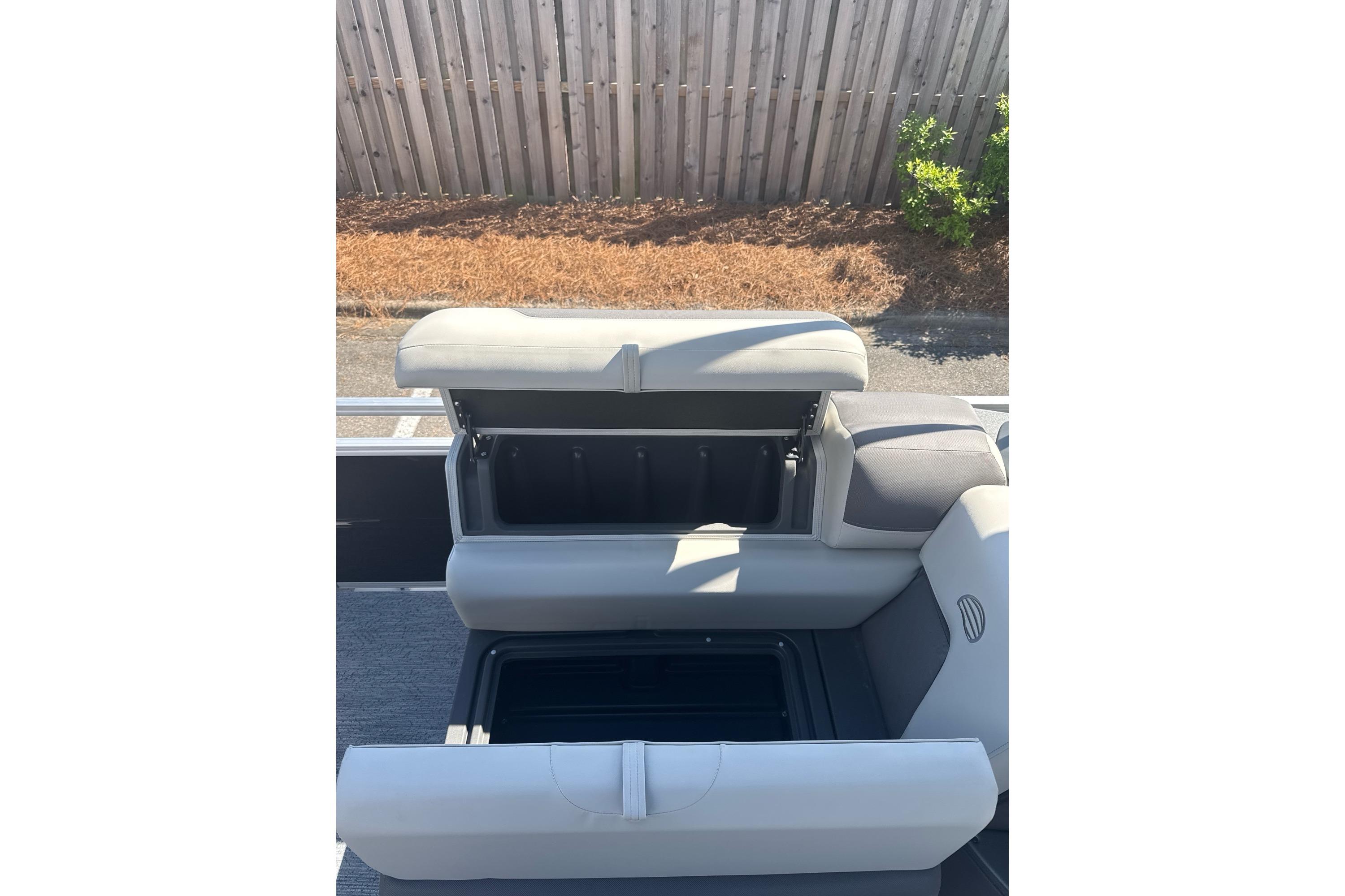 2026 Sun Tracker Fishin' Barge 20 DLX boat seat with open storage compartment.