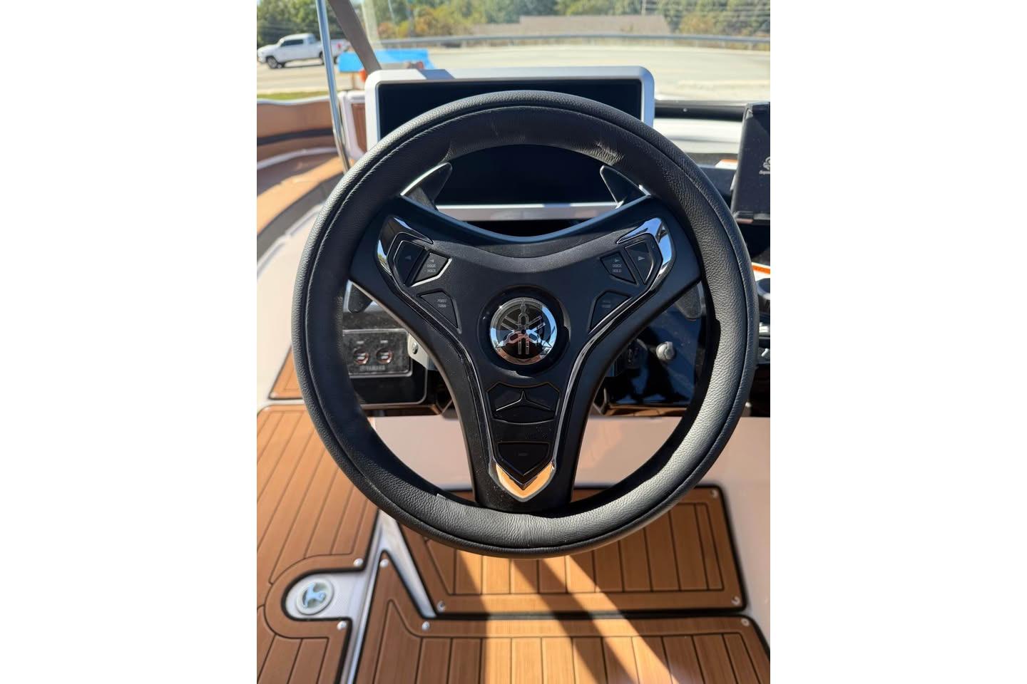 Steering wheel of 2026 Yamaha Boats 252SD, featuring sleek design and modern controls.