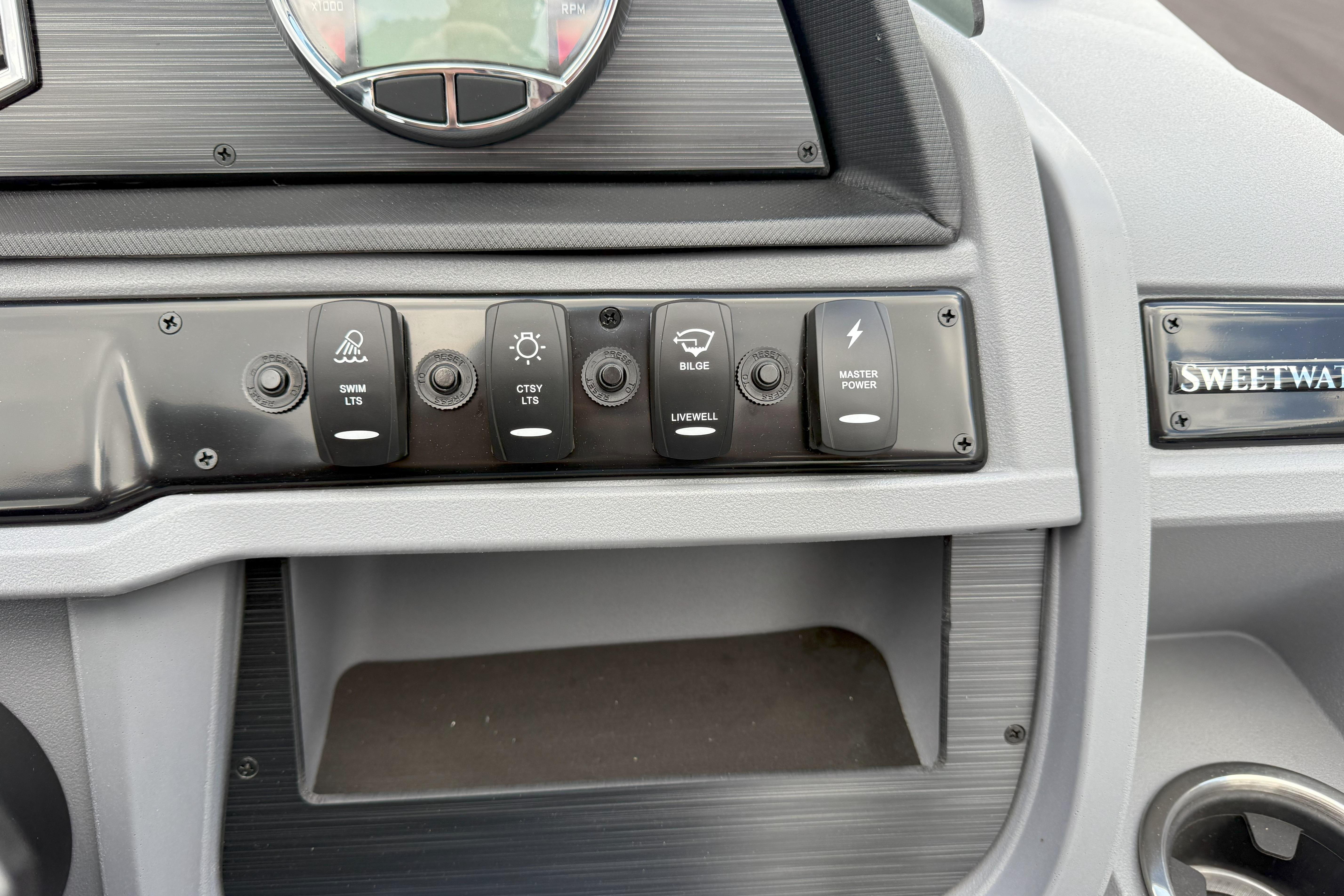 Control panel of 2026 Godfrey SWEETWATER 2286 SFL boat with labeled switches.