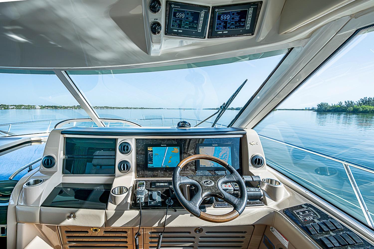 Helm of 2008 Sea Ray 60 Sundancer yacht with navigation screens and steering wheel.
