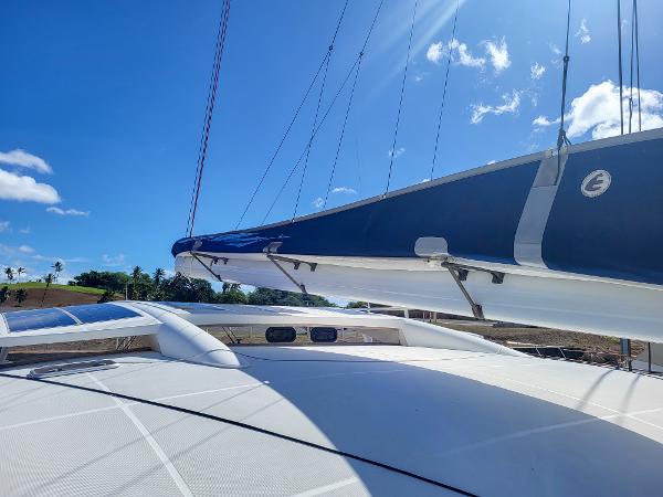 2009 Catana 65 sailboat deck and sail under clear blue sky.
