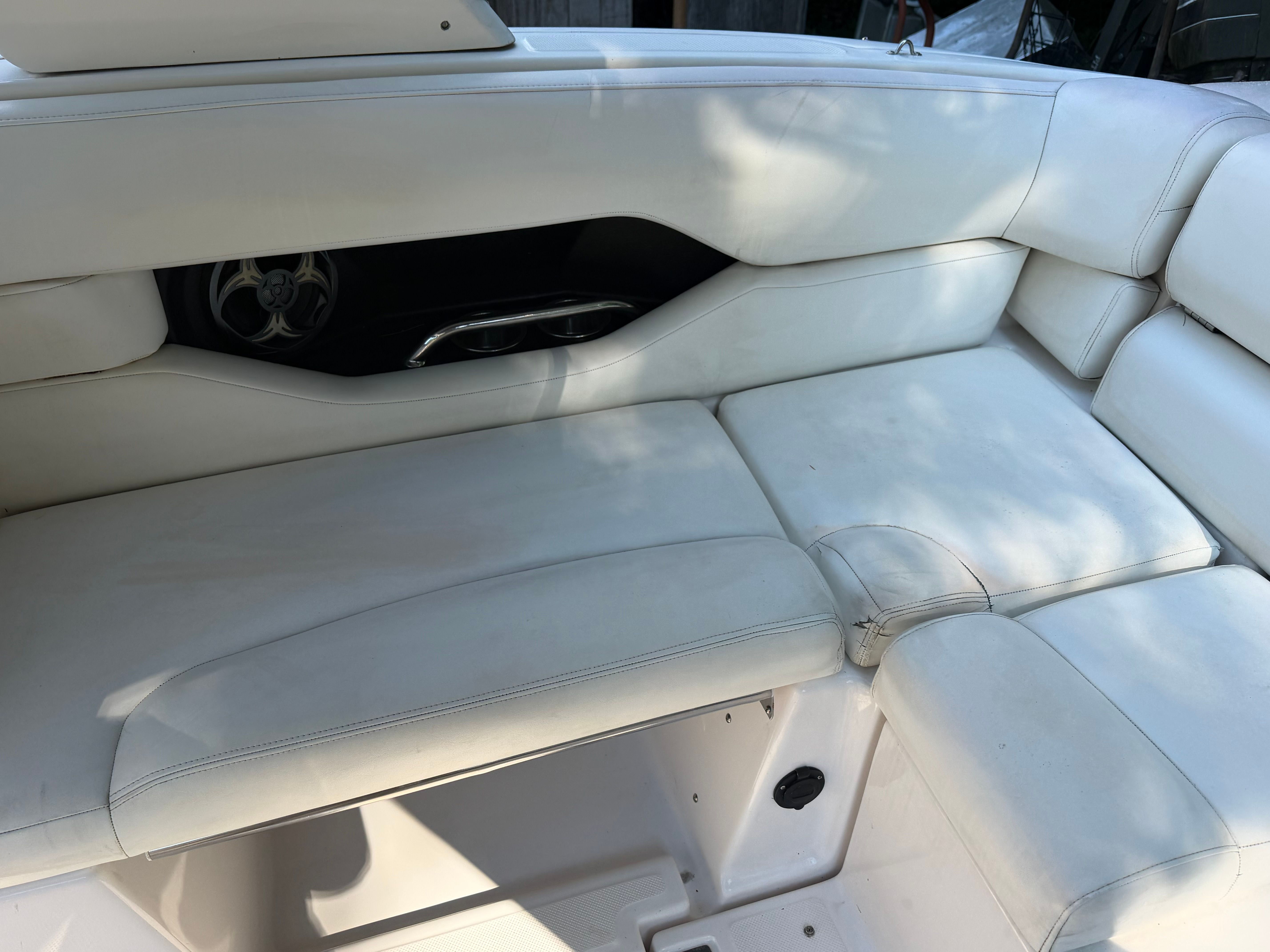The boat's white seating area features cushioned seats and a built-in speaker opening.