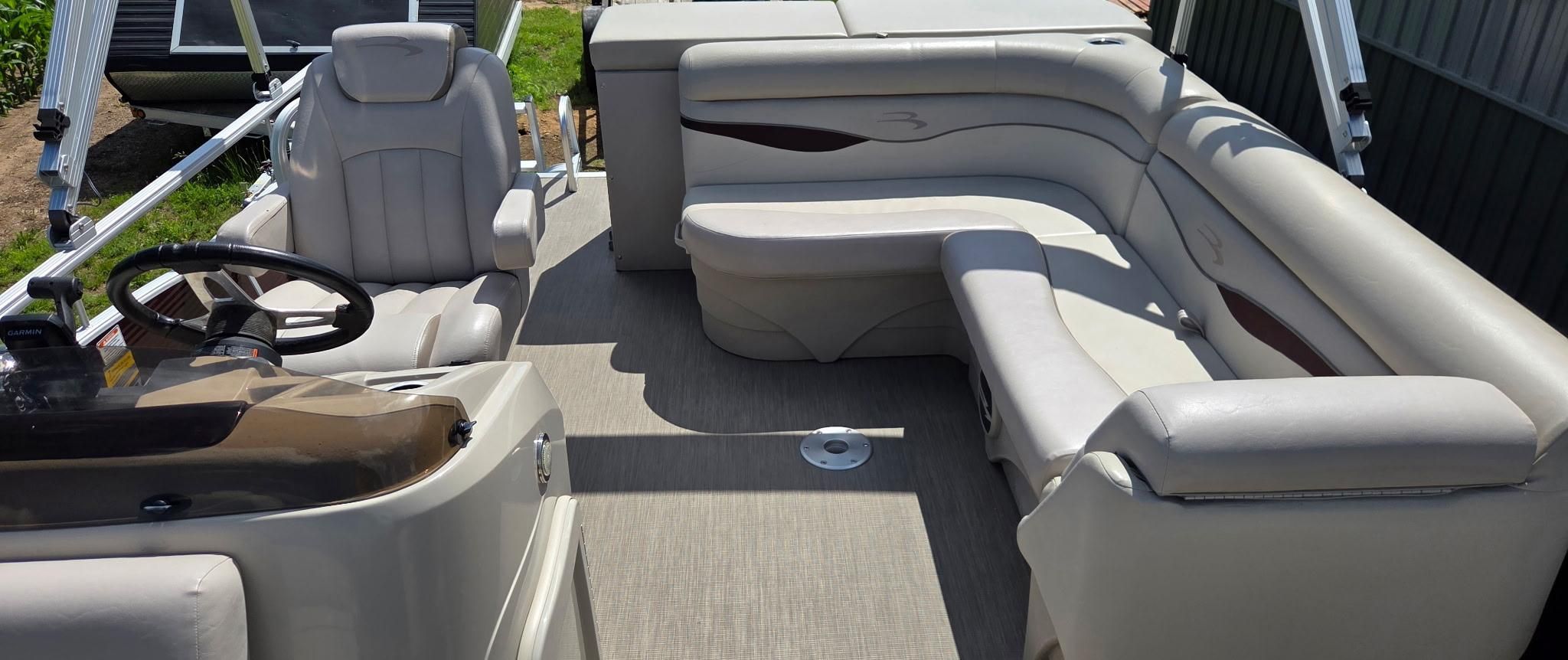 The image shows the interior of a 2018 Bennington 18SL pontoon boat with beige seating.