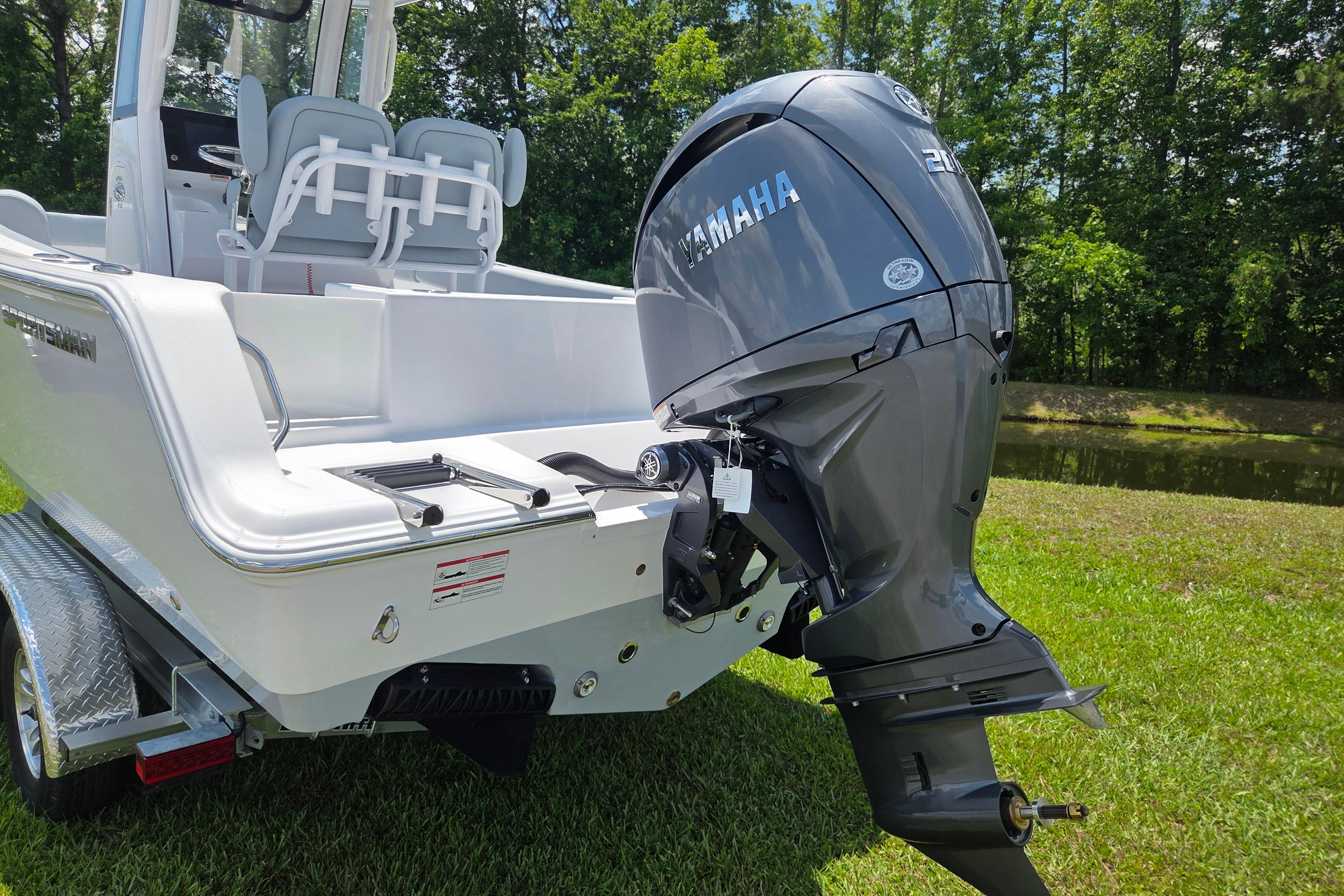 2026 Sportsman Open 212 Center Console boat with Yamaha outboard motor on grass.