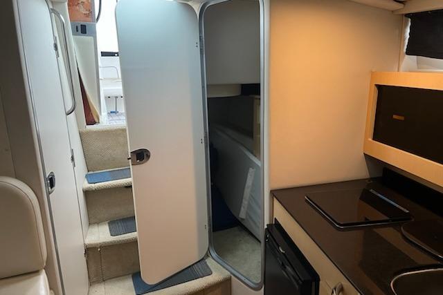 Interior of 2012 Bayliner 285 Cruiser with kitchenette and cabin access.