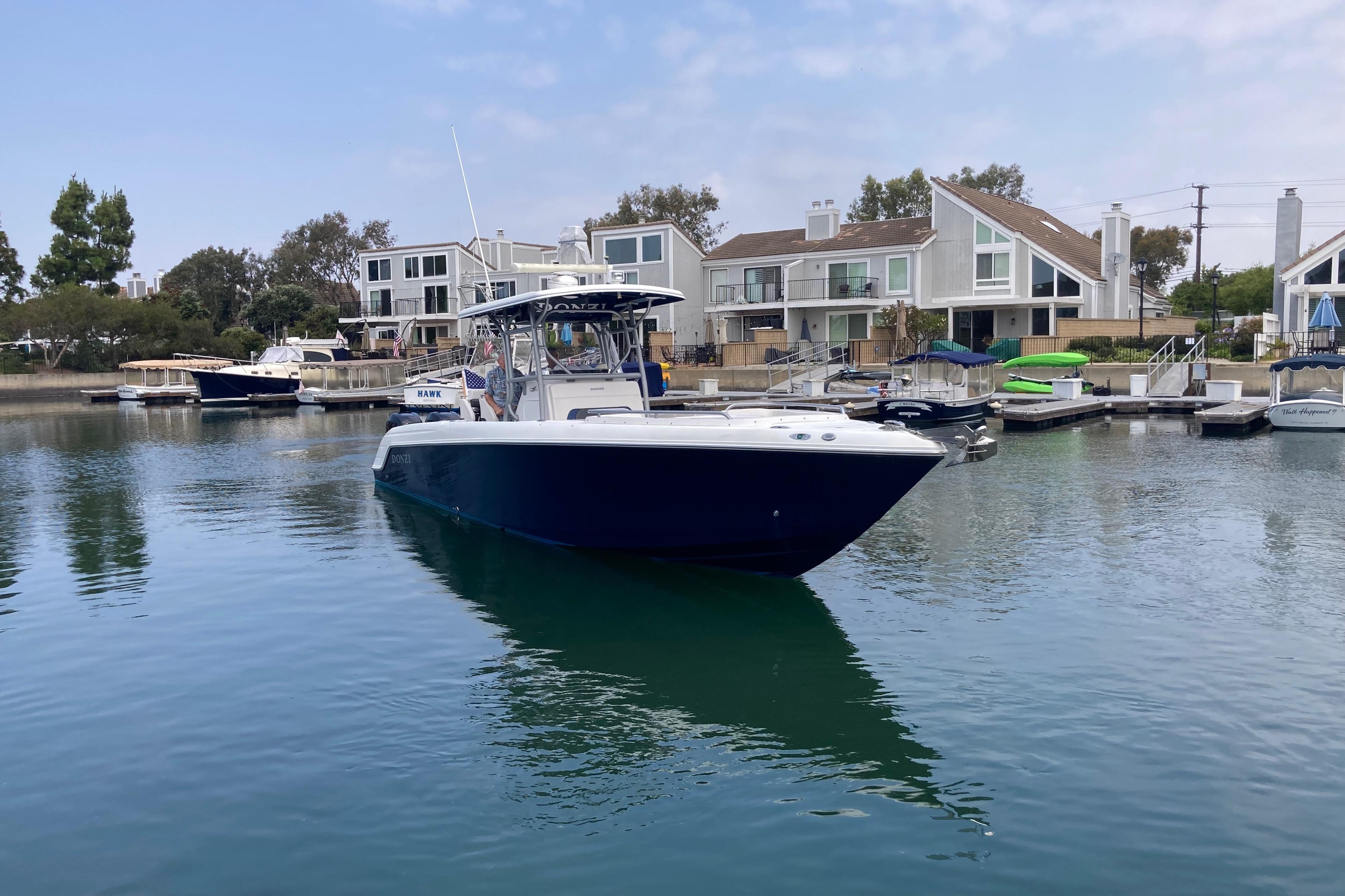 2011 Donzi 38 ZFX Open boat docked in a serene marina setting.