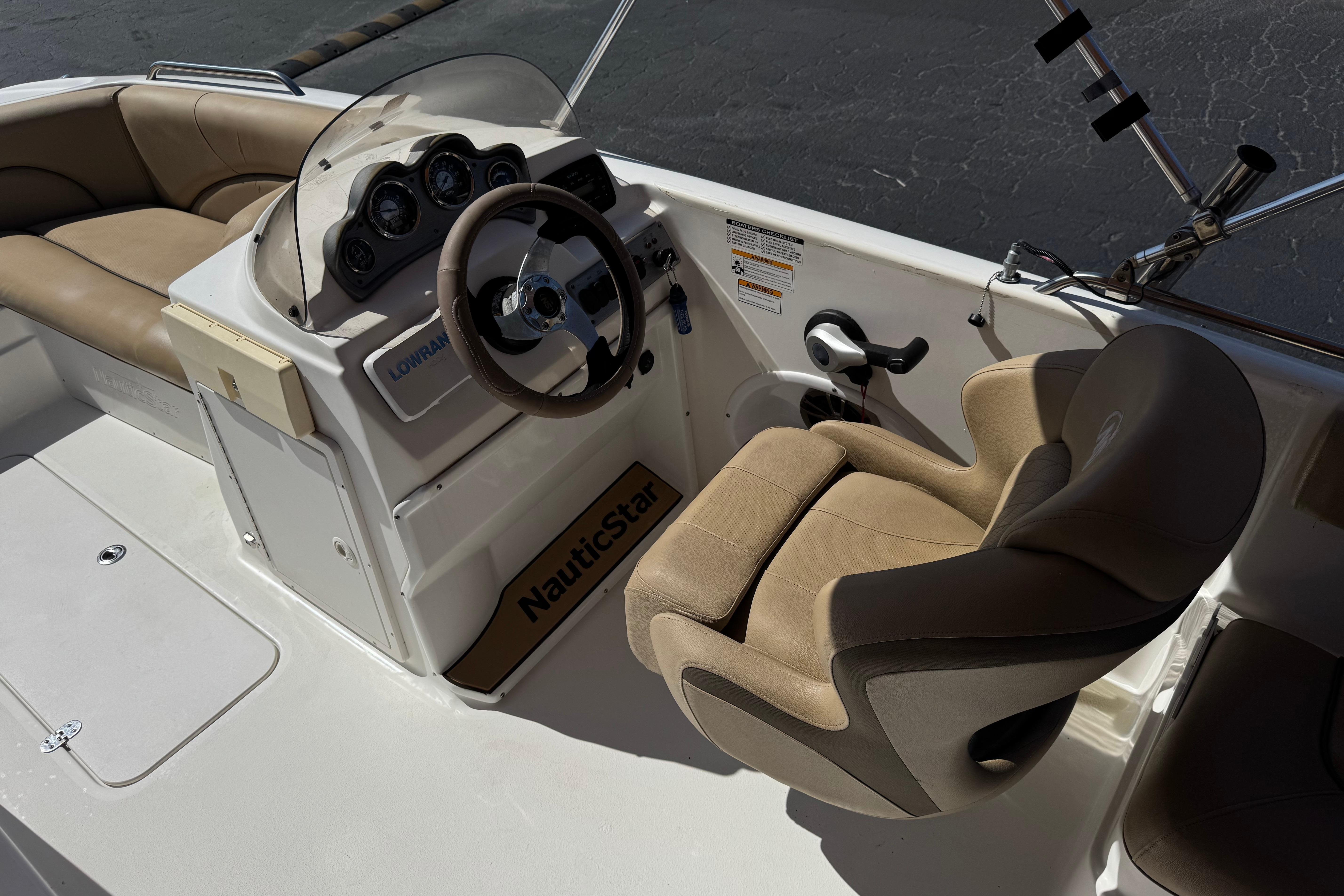 2020 NauticStar 203 SC boat interior with steering wheel and beige seating.