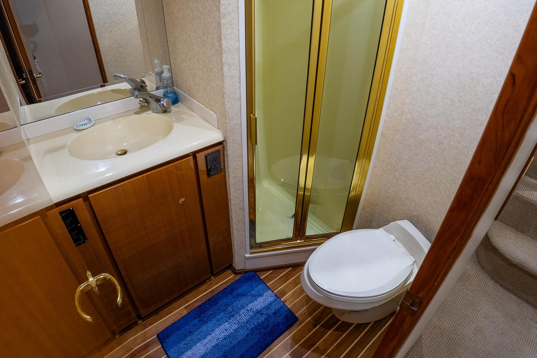 Luxurious bathroom in 2002 Viking 61 Enclosed Bridge yacht with shower and toilet.