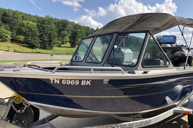 2023 Alumaweld Talon 18 boat on trailer, blue exterior, parked outdoors.