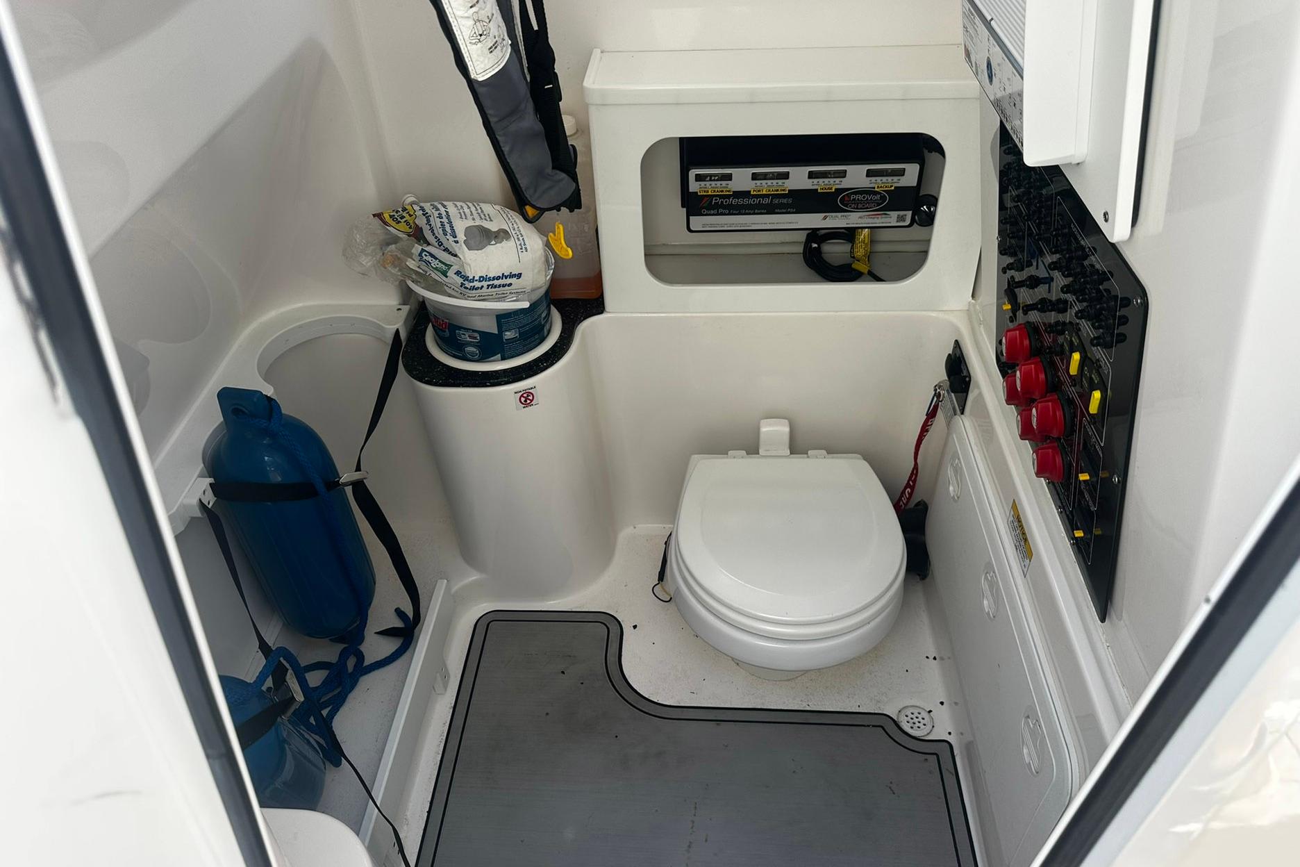 Interior of a 2002 Sea Fox 228 Commander boat featuring a compact marine toilet.