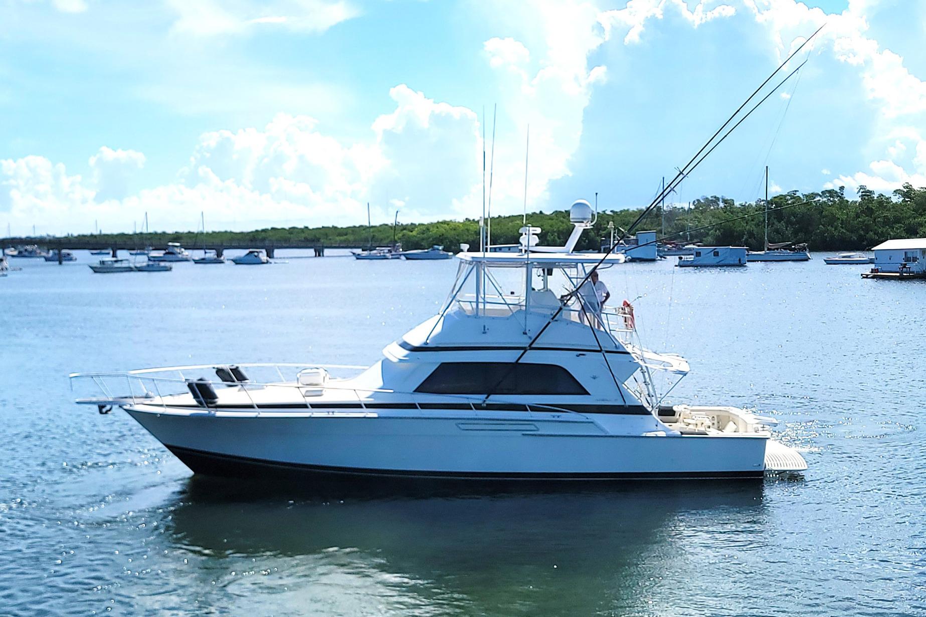 1989 Bertram 50 Convertible yacht on calm water, clear sky background.