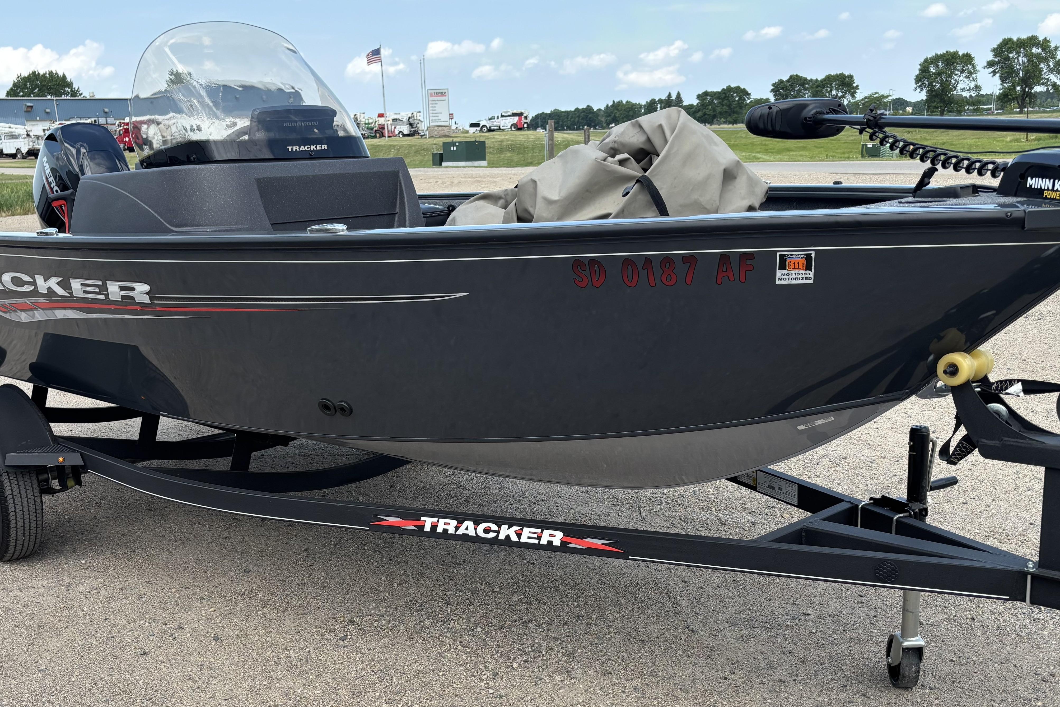 2021 Tracker Pro Guide V-16 WT boat on trailer, parked outdoors.