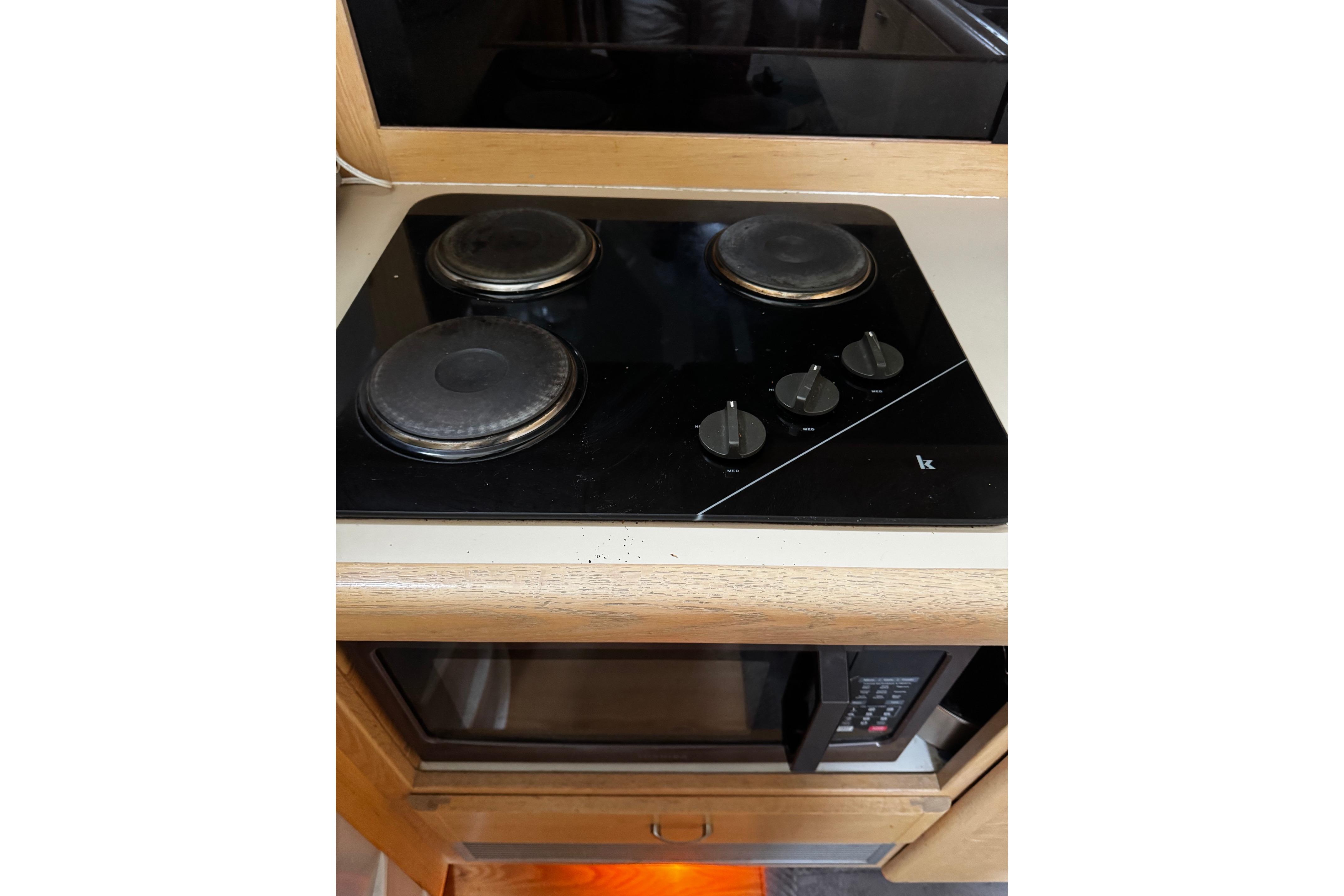 Stovetop and microwave in 1991 Silverton 46 Motor Yacht kitchen area.