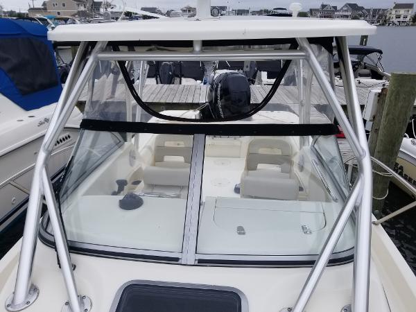 2011 Boston Whaler 235 Conquest boat docked, showcasing cabin and windshield.