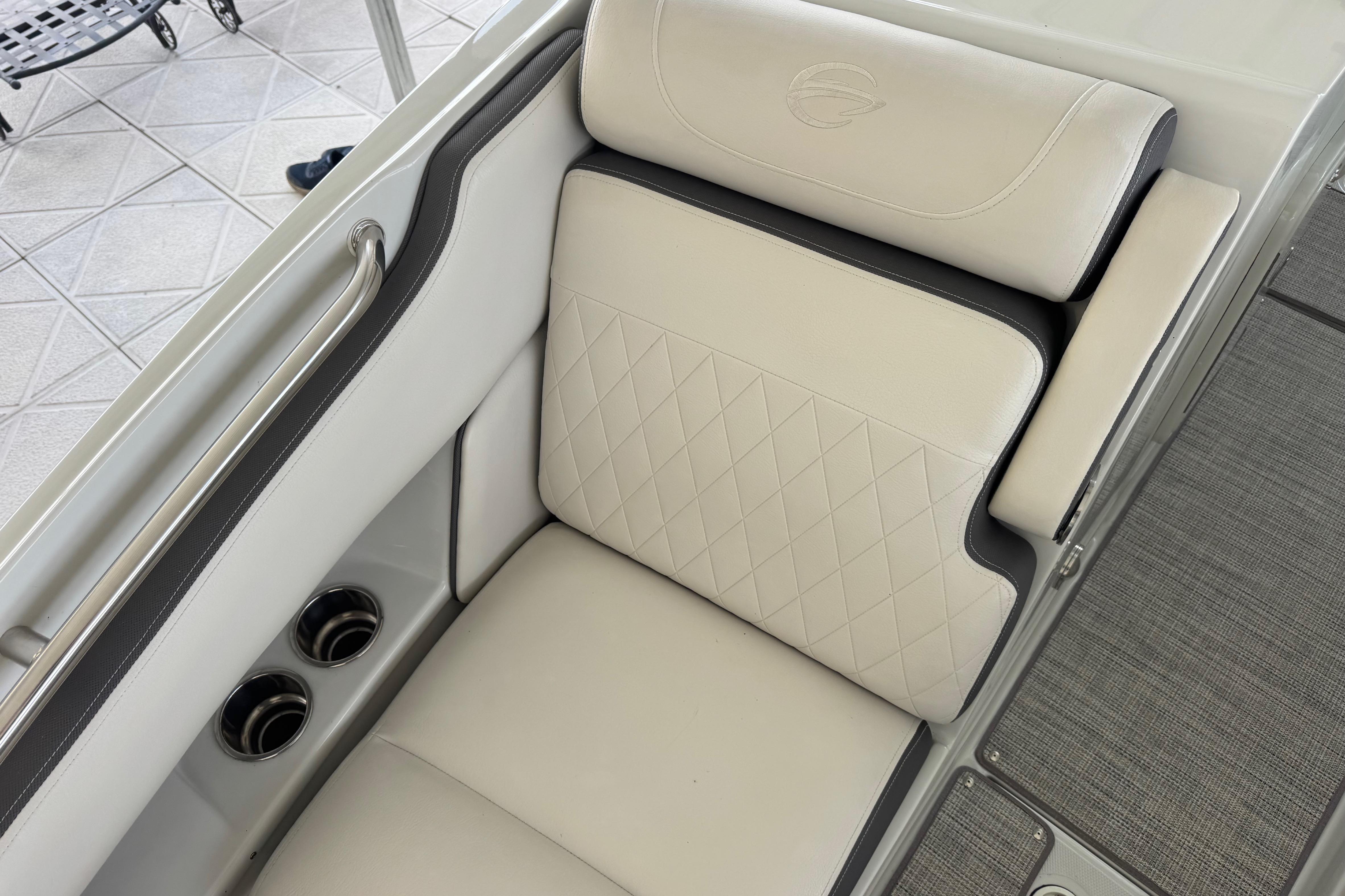 Luxurious seating in 2022 Crownline 265 SS boat with diamond-stitched upholstery and cup holders.