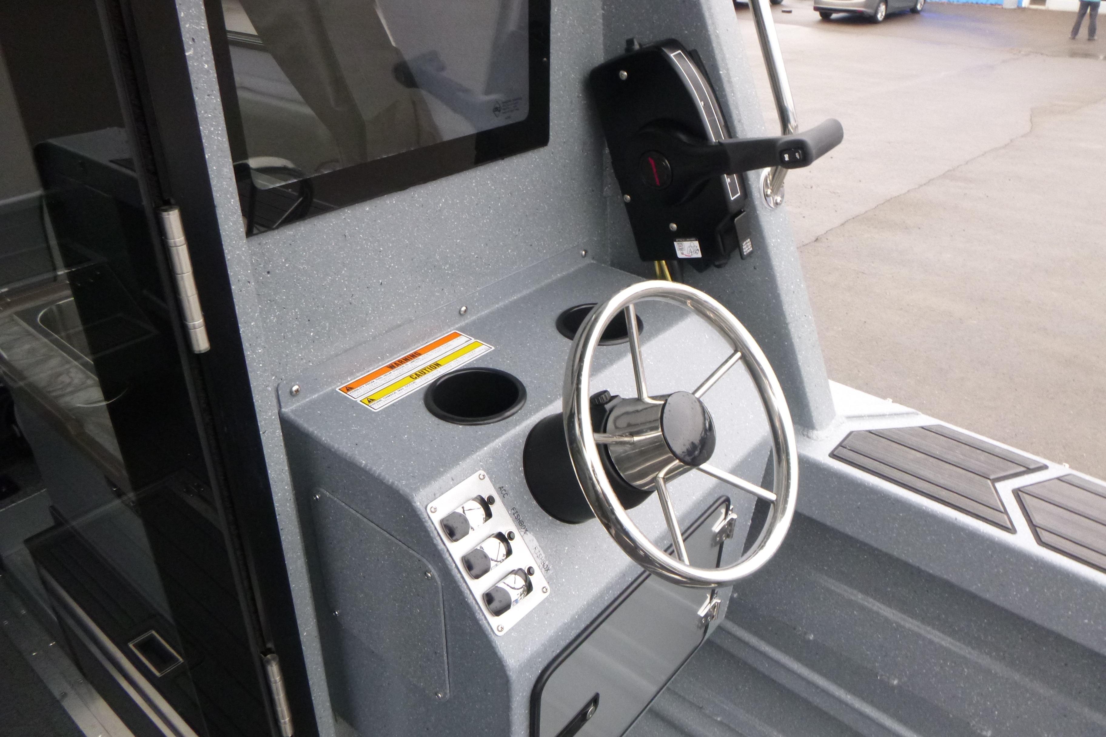 2026 KingFisher 25 XAC boat helm with steering wheel and control panel.