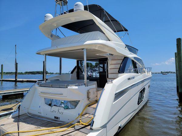 2019 Absolute 50 Fly yacht docked at marina under clear blue sky.