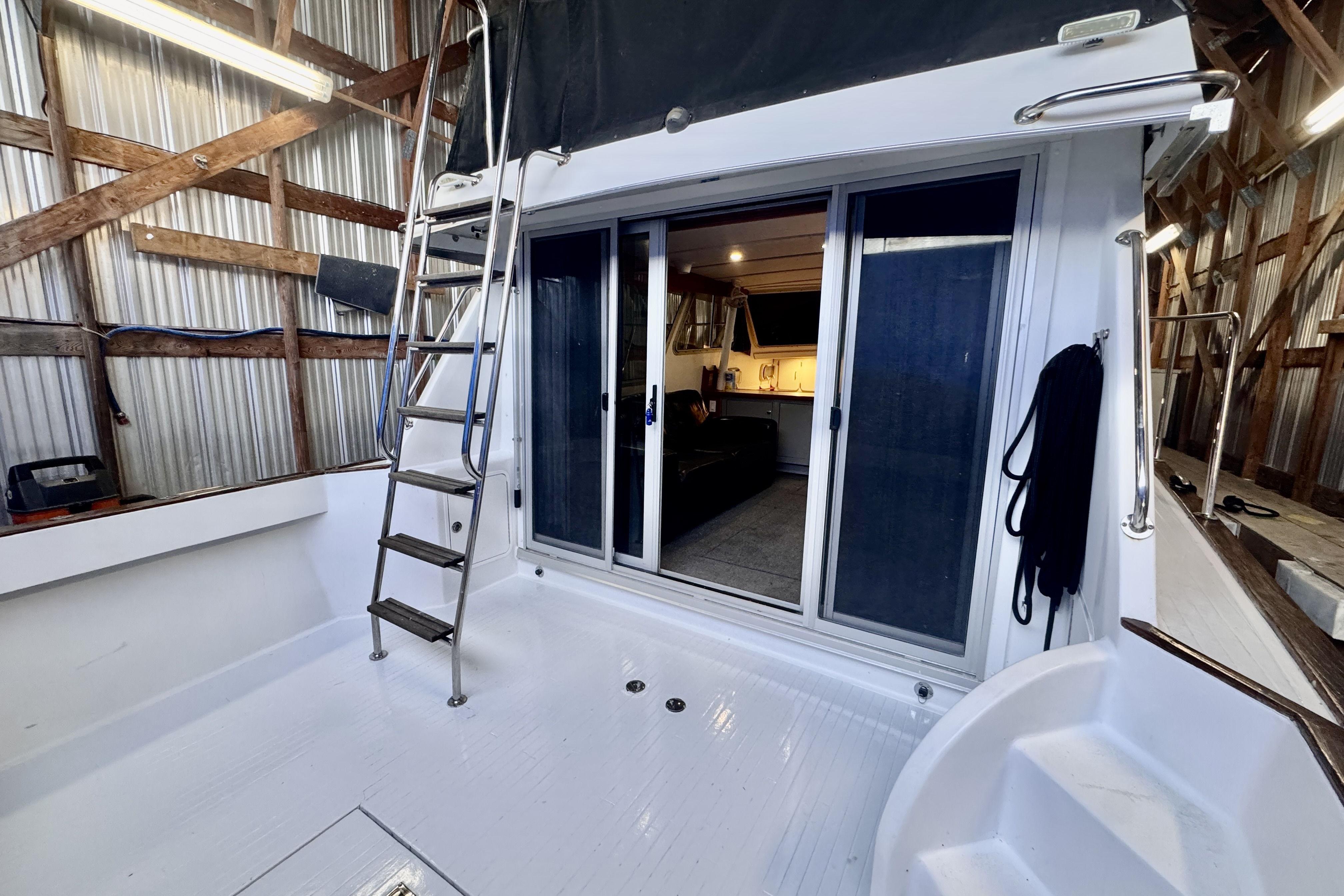 1974 Tollycraft 37 yacht interior with sliding doors and ladder in a boathouse.