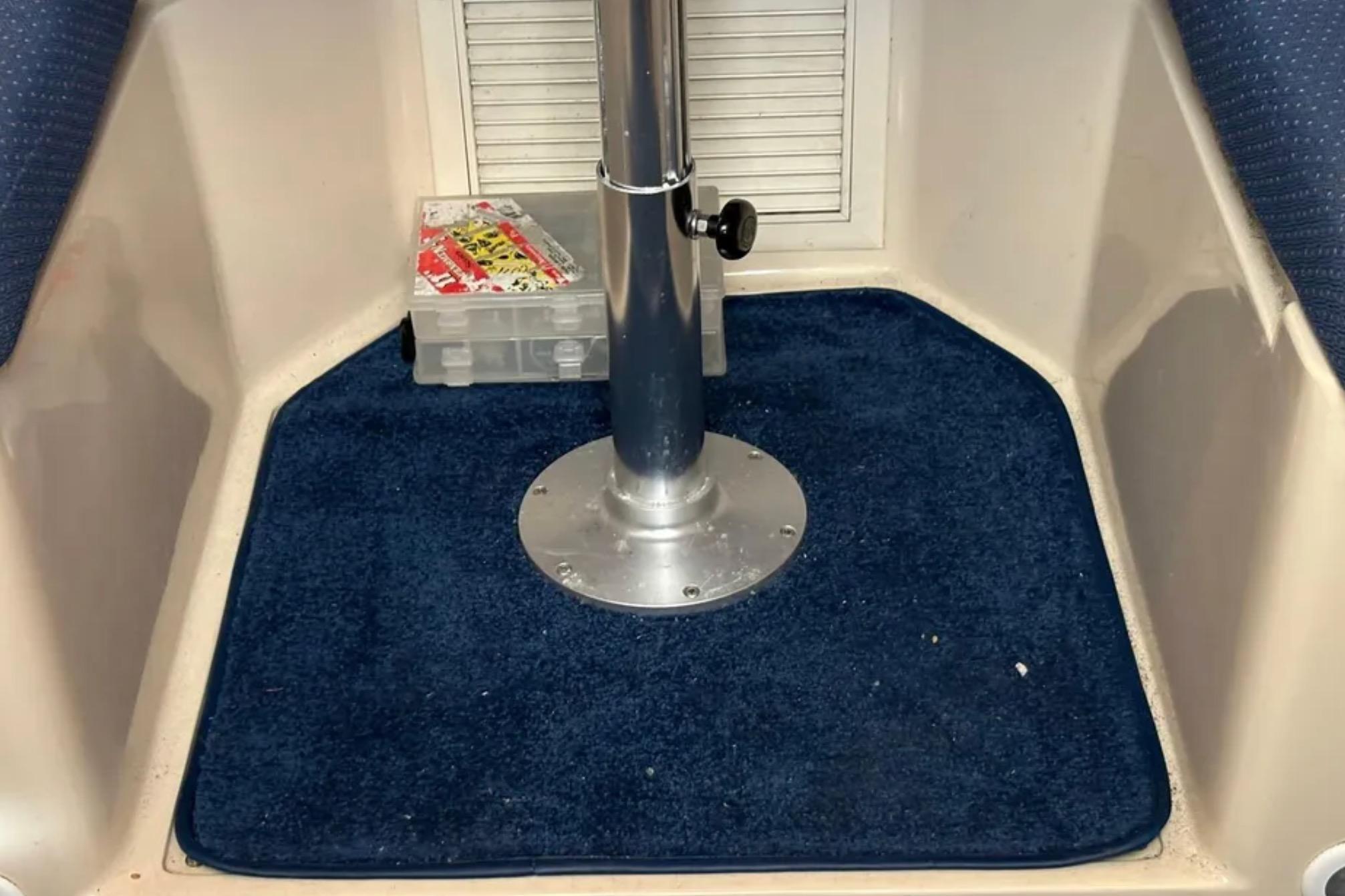 Interior of 2005 Albin 28 Tournament Express with blue carpet and metal pedestal.