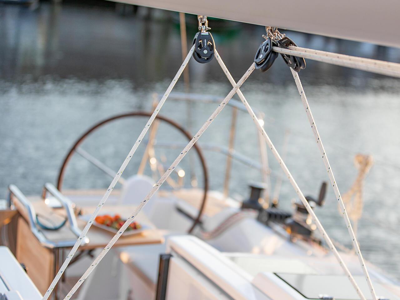 Close-up of 2024 Hanse 348 sailboat cockpit with rigging and steering wheel.