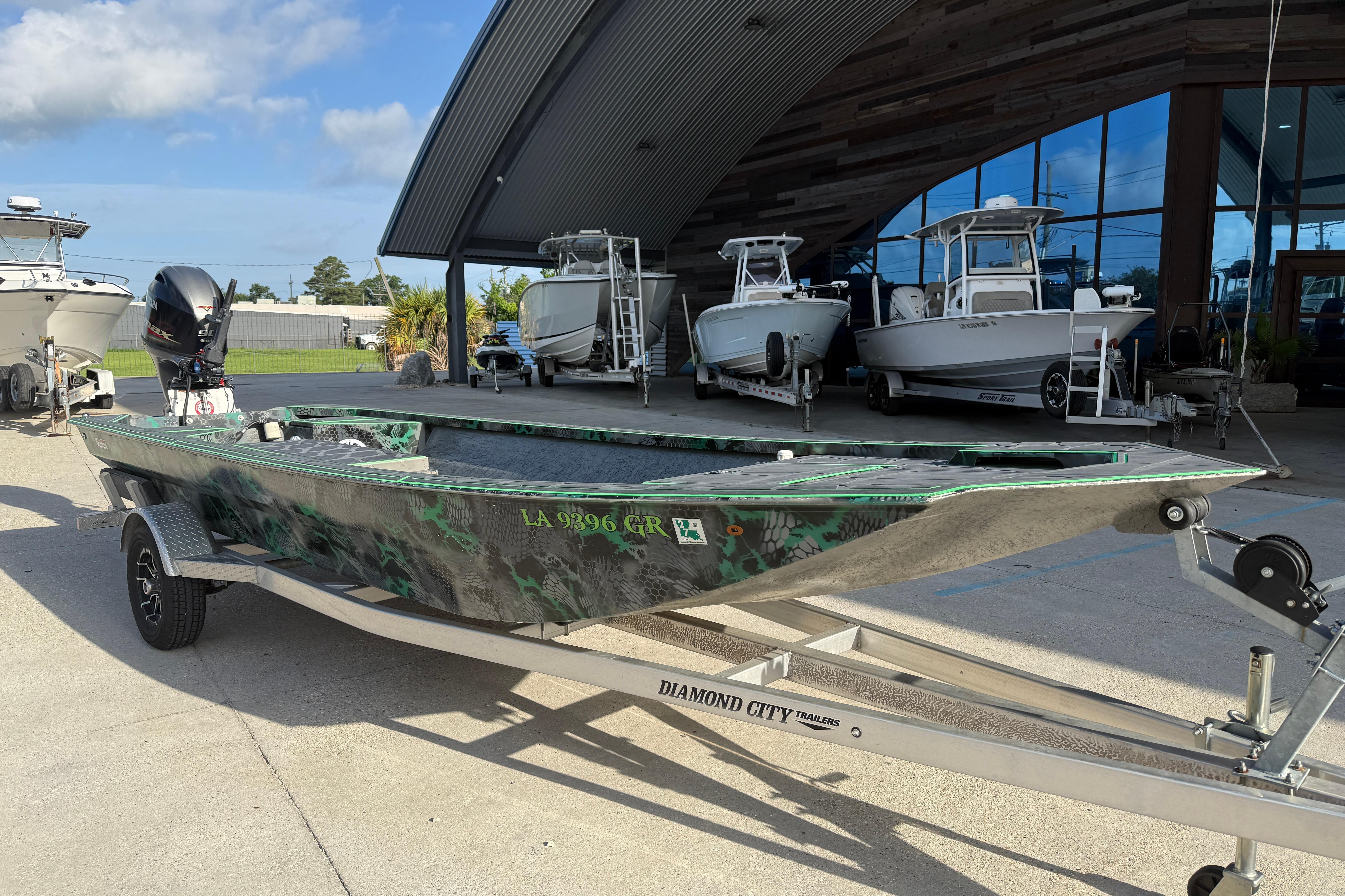 Custom Rene Gros 20x48 boat on trailer, 2024 model, parked outside showroom.