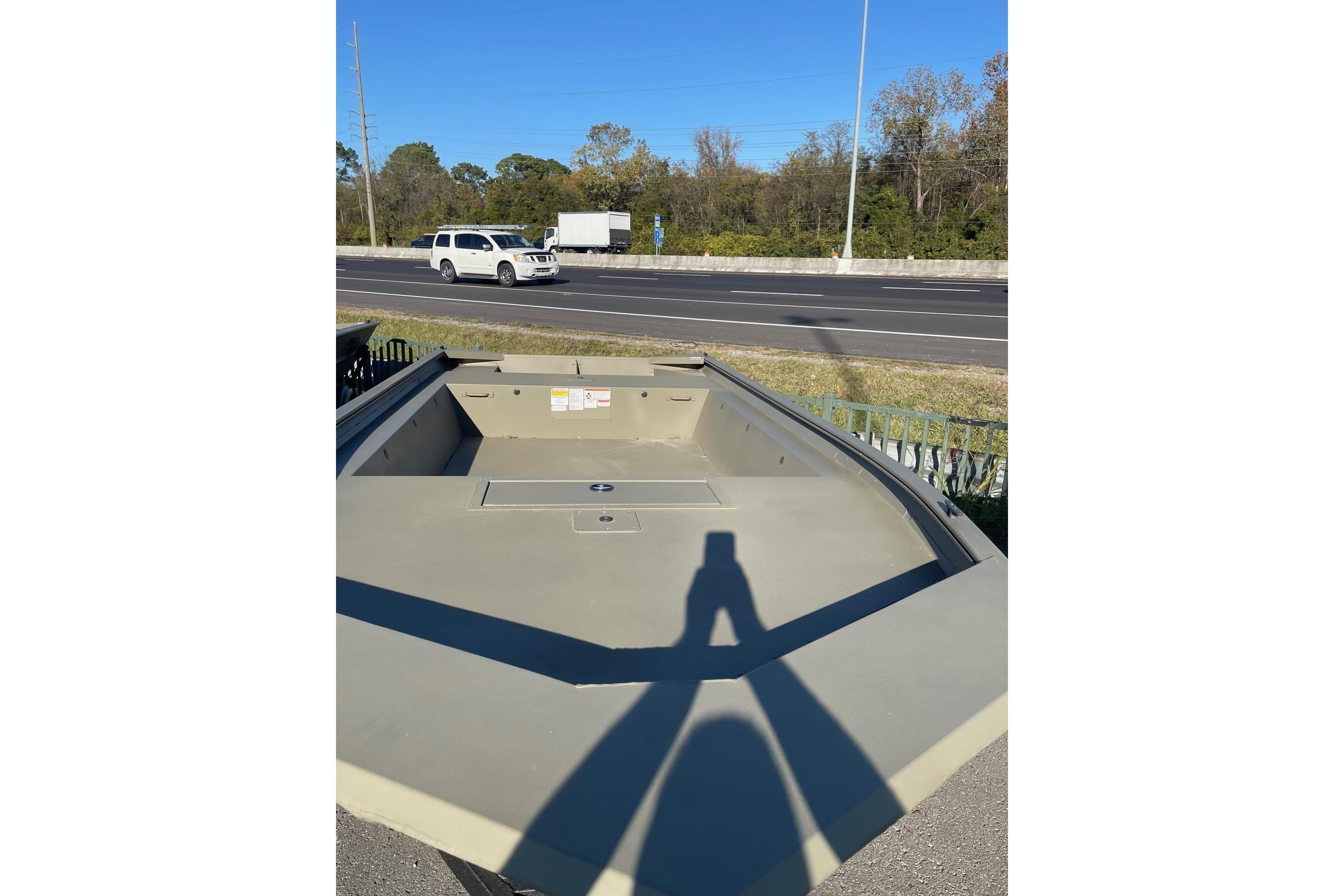 2026 Tracker Grizzly 1754 Utility boat parked near a road under clear blue sky.