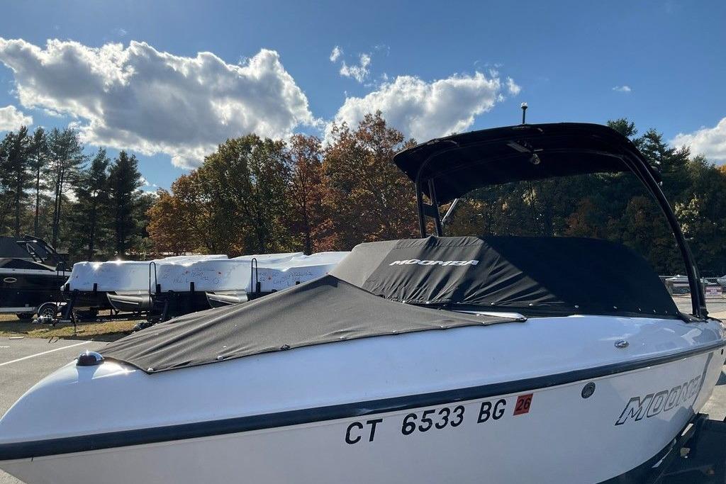 2015 Moomba Outback V boat with cover, parked outdoors under a partly cloudy sky.