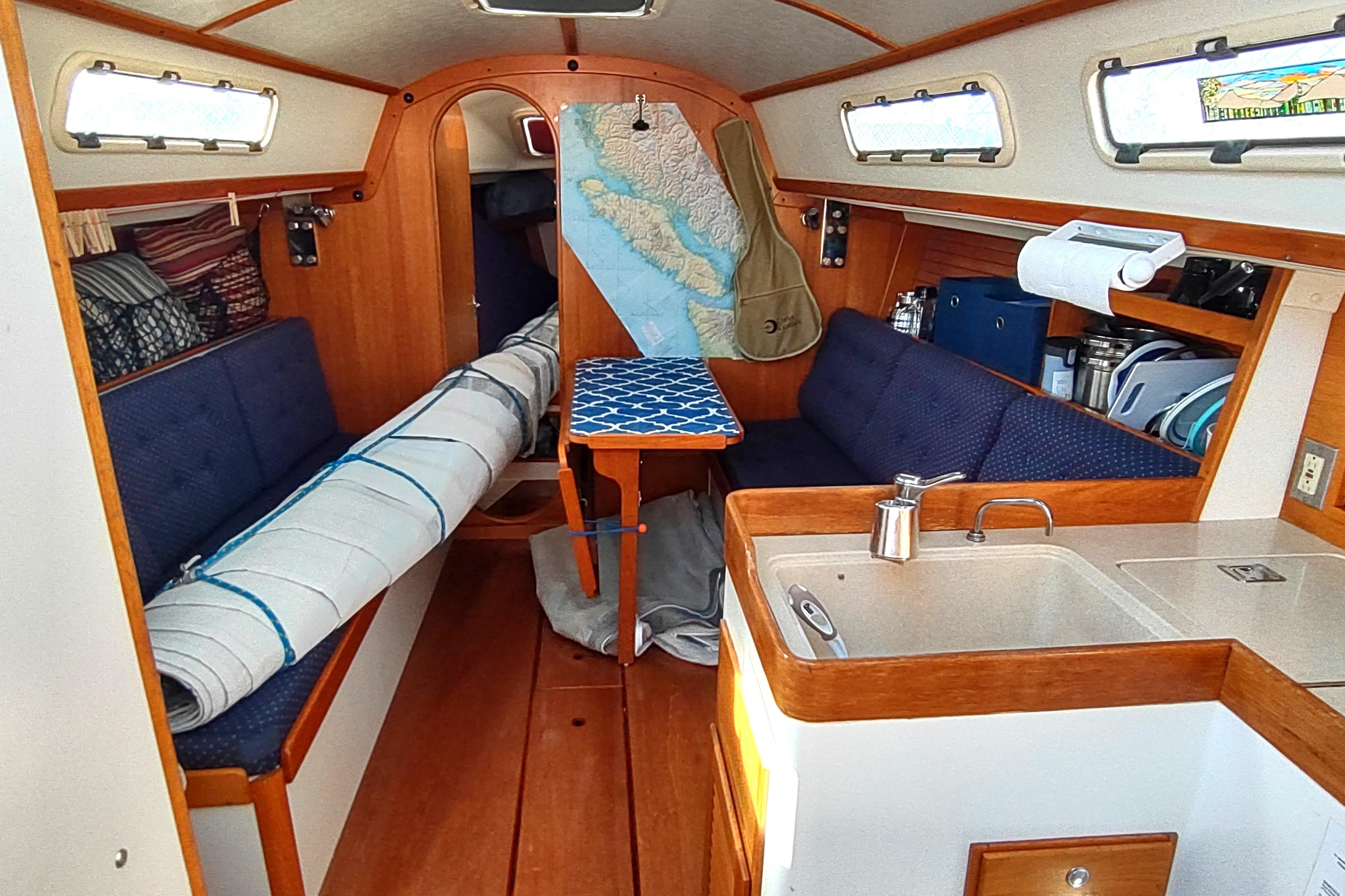 Interior of a 1998 J Boats J/32 sailboat with cozy seating and compact kitchen.