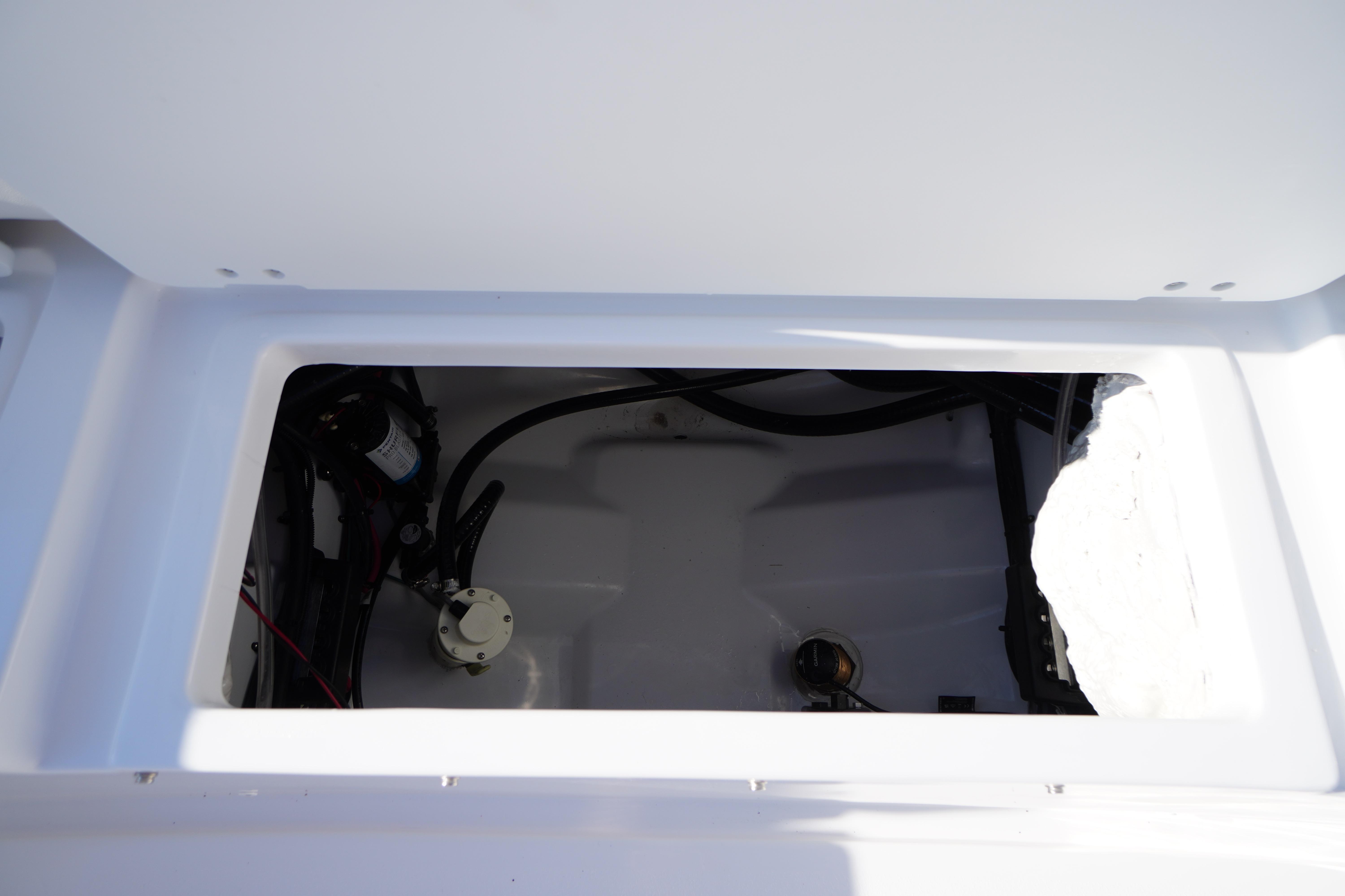 2026 Tidewater 272 LXF boat storage compartment with visible wiring and components.