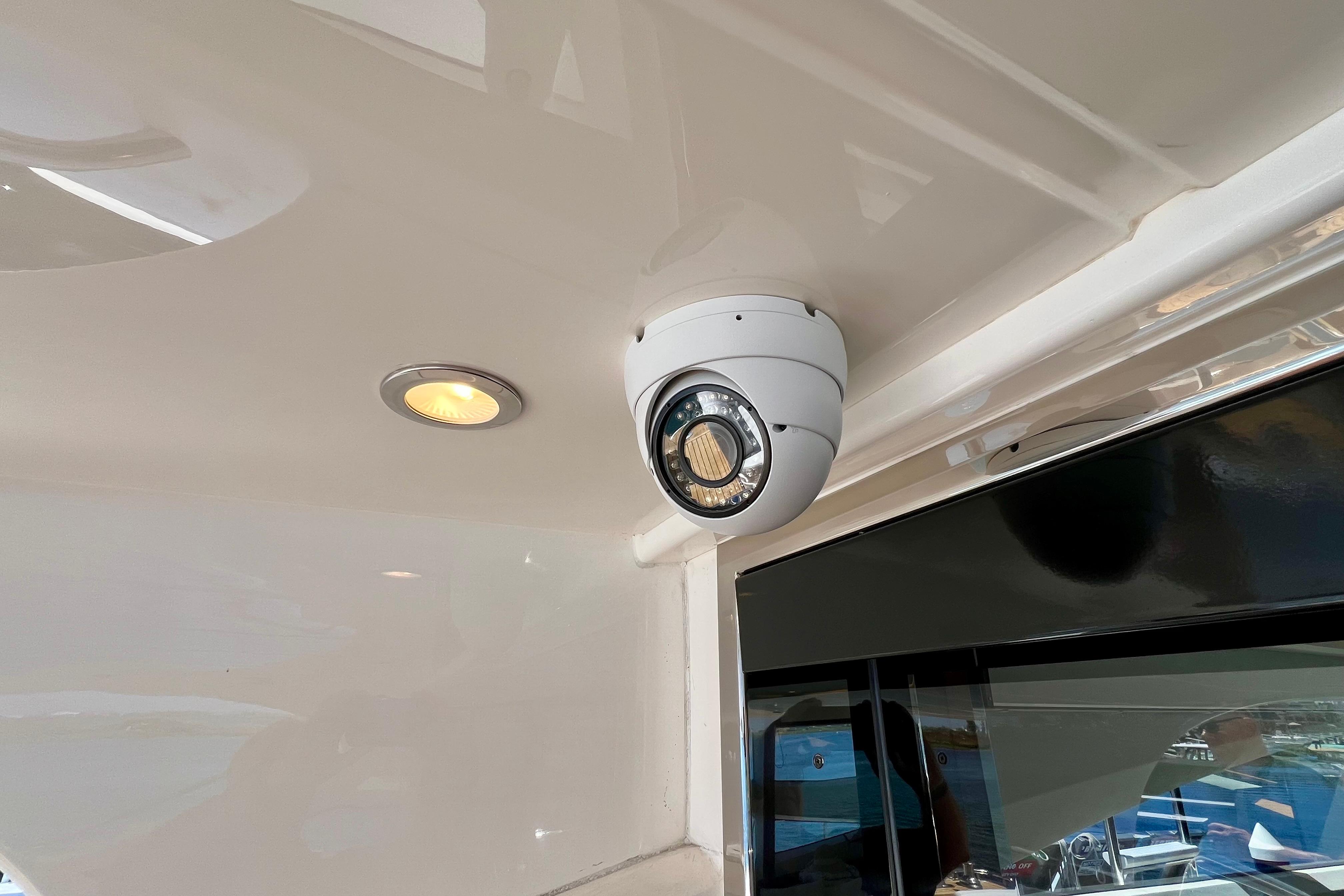 Security camera on 2010 Princess V78 yacht ceiling, near recessed light.