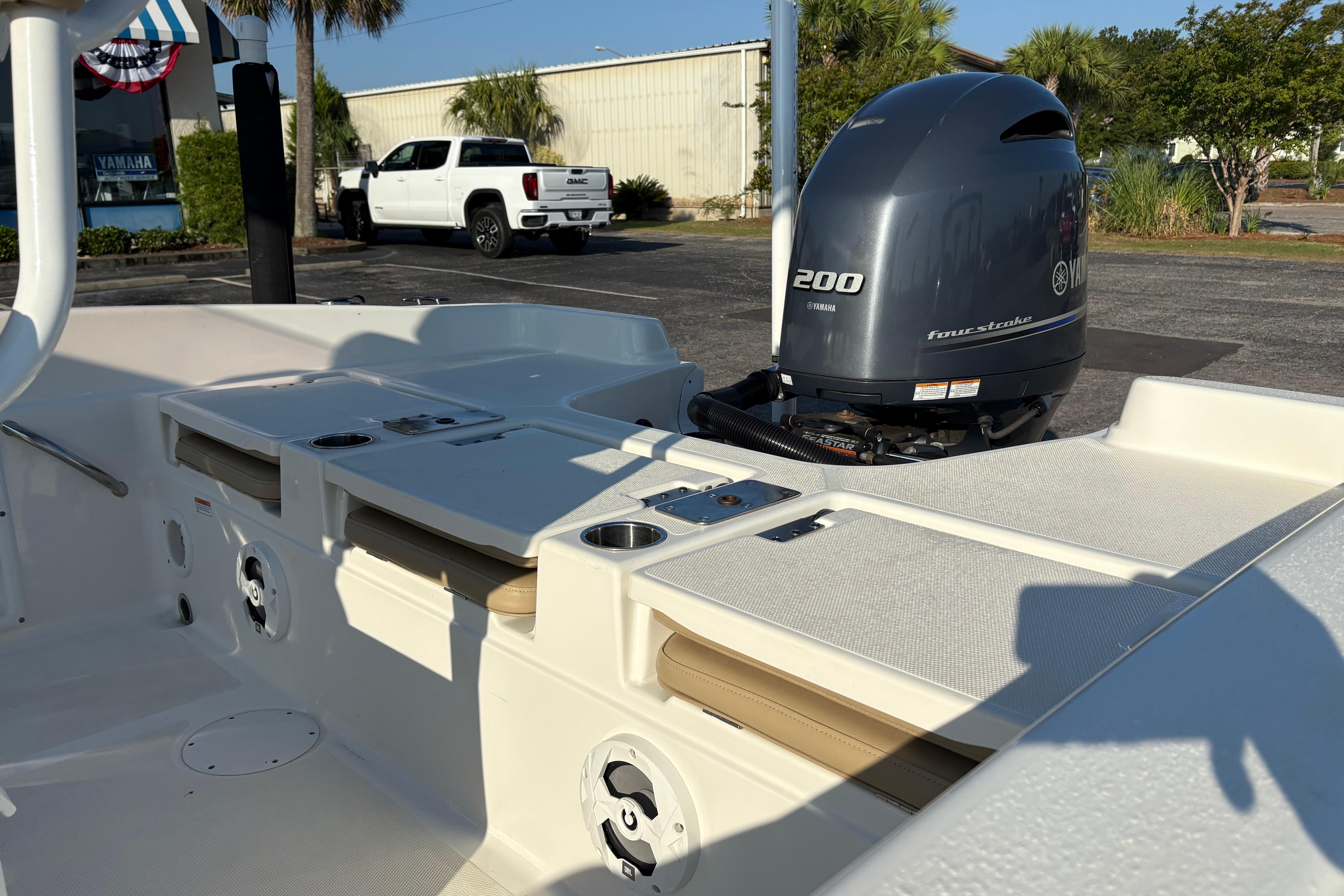 2019 NauticStar 231 Hybrid boat with Yamaha 200 four-stroke engine in a sunny parking lot.